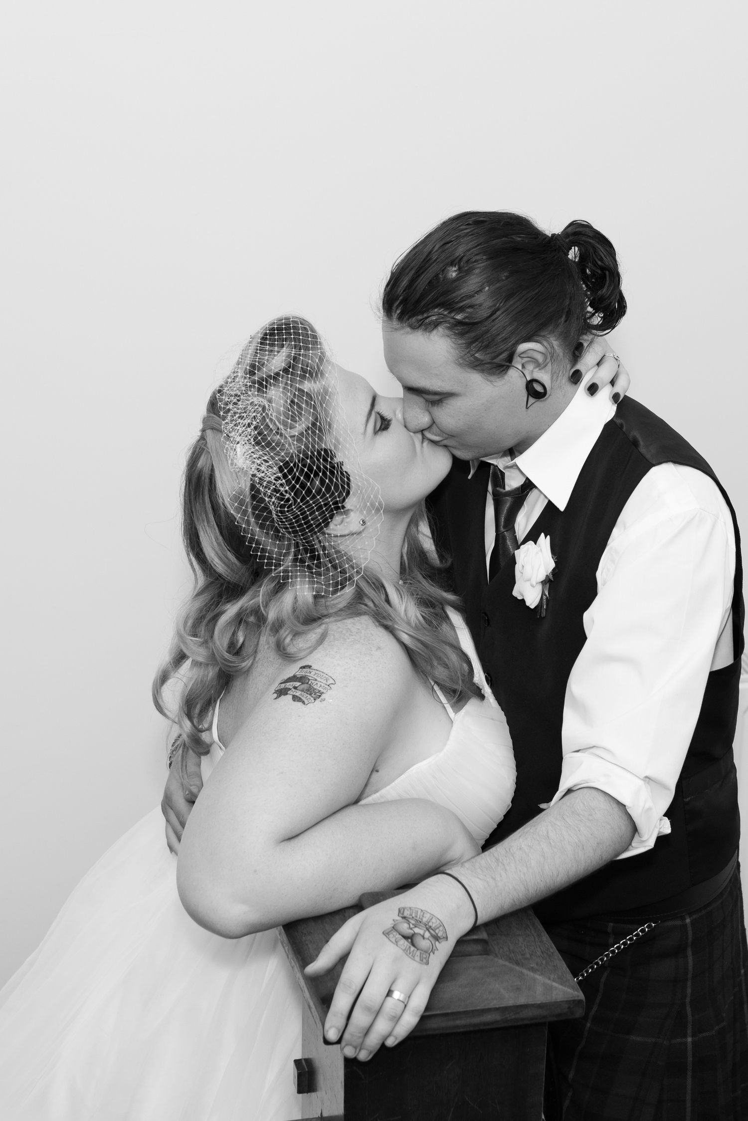 Romantic black and white portrait with vintage-style veil and formal attire.