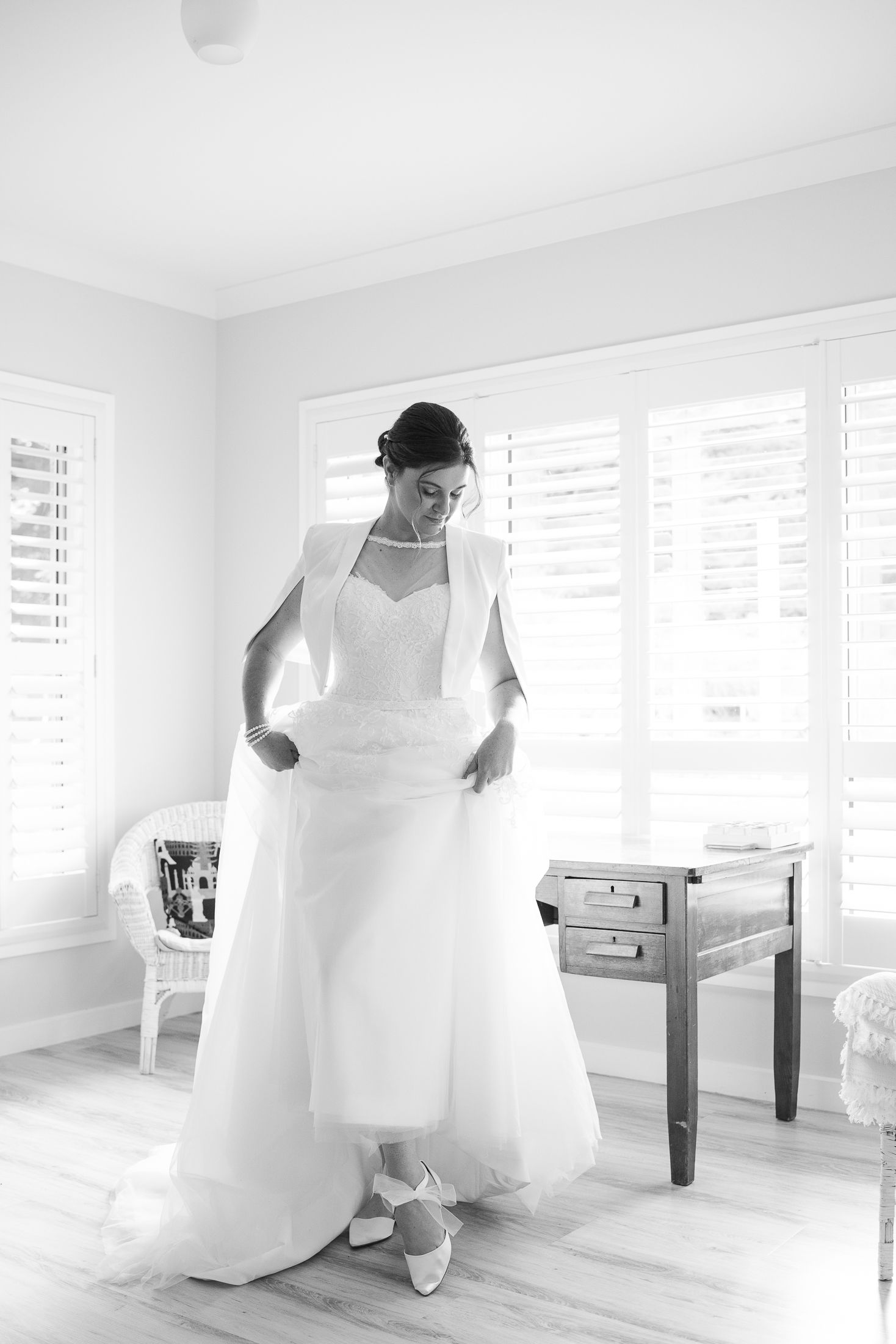 Bride showing her special shoes on her wedding day in a black and white elegant photo.