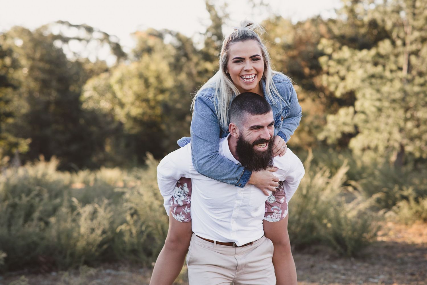 Candid laughter during a playful piggyback ride outdoors.