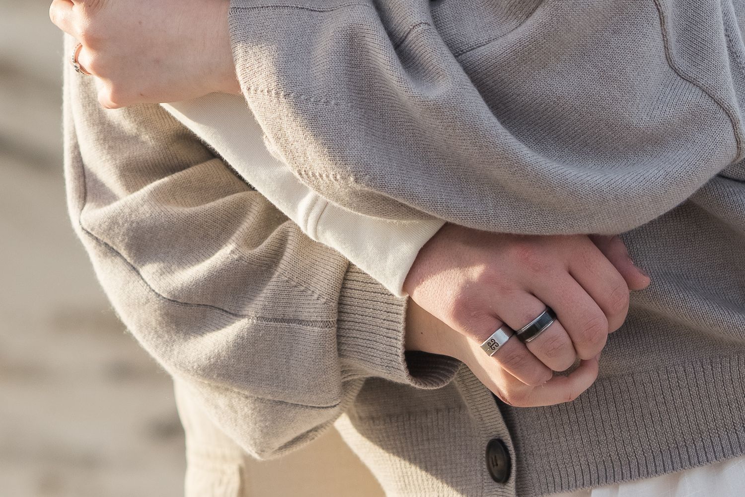 Close-up detail of hands wearing grey sweater sleeves.