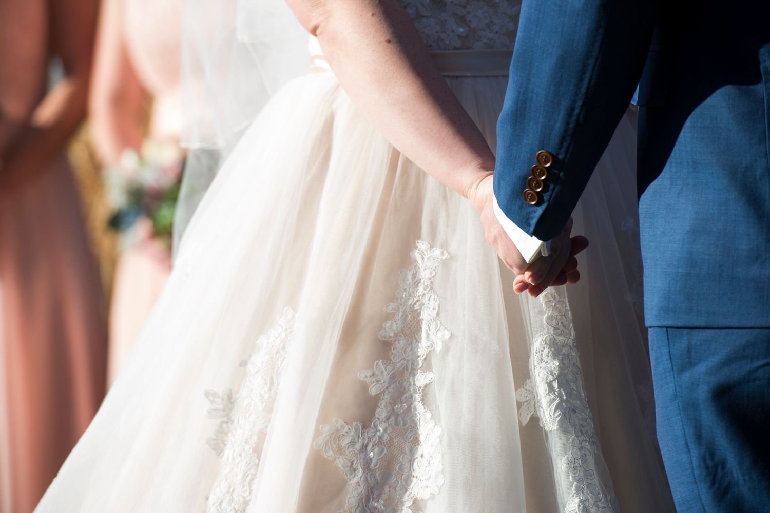Couple holding hands during wedding ceremony.