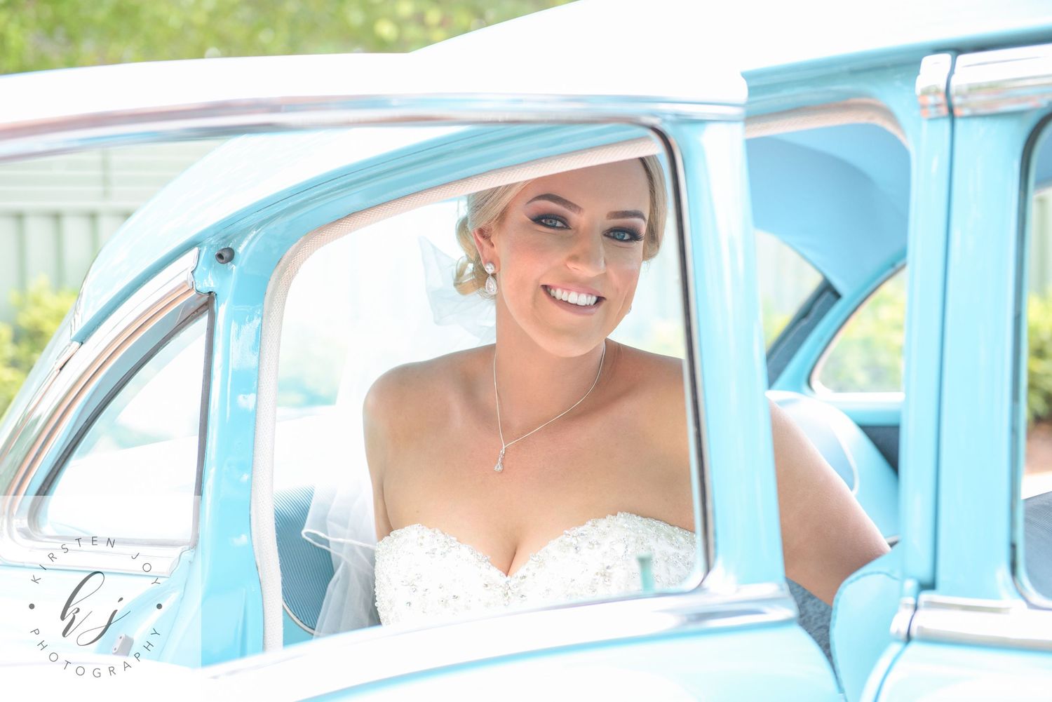 Row of classic light blue vintage cars parked outdoors for a wedding.