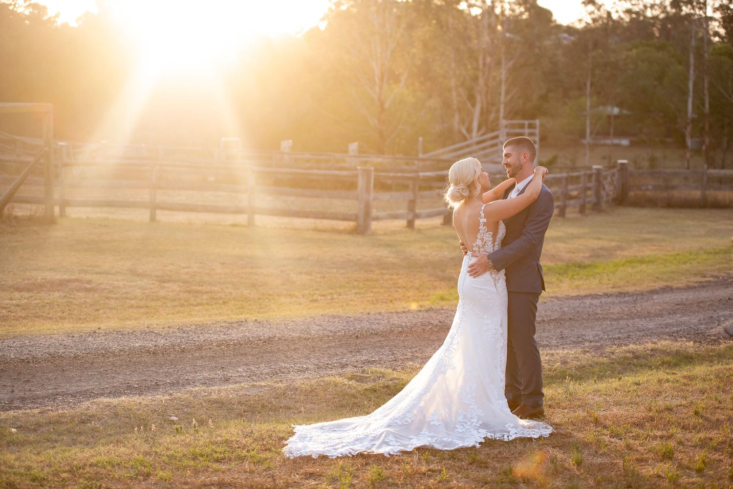 A golden hour wedding portrait with sunbeams streaming through the trees.