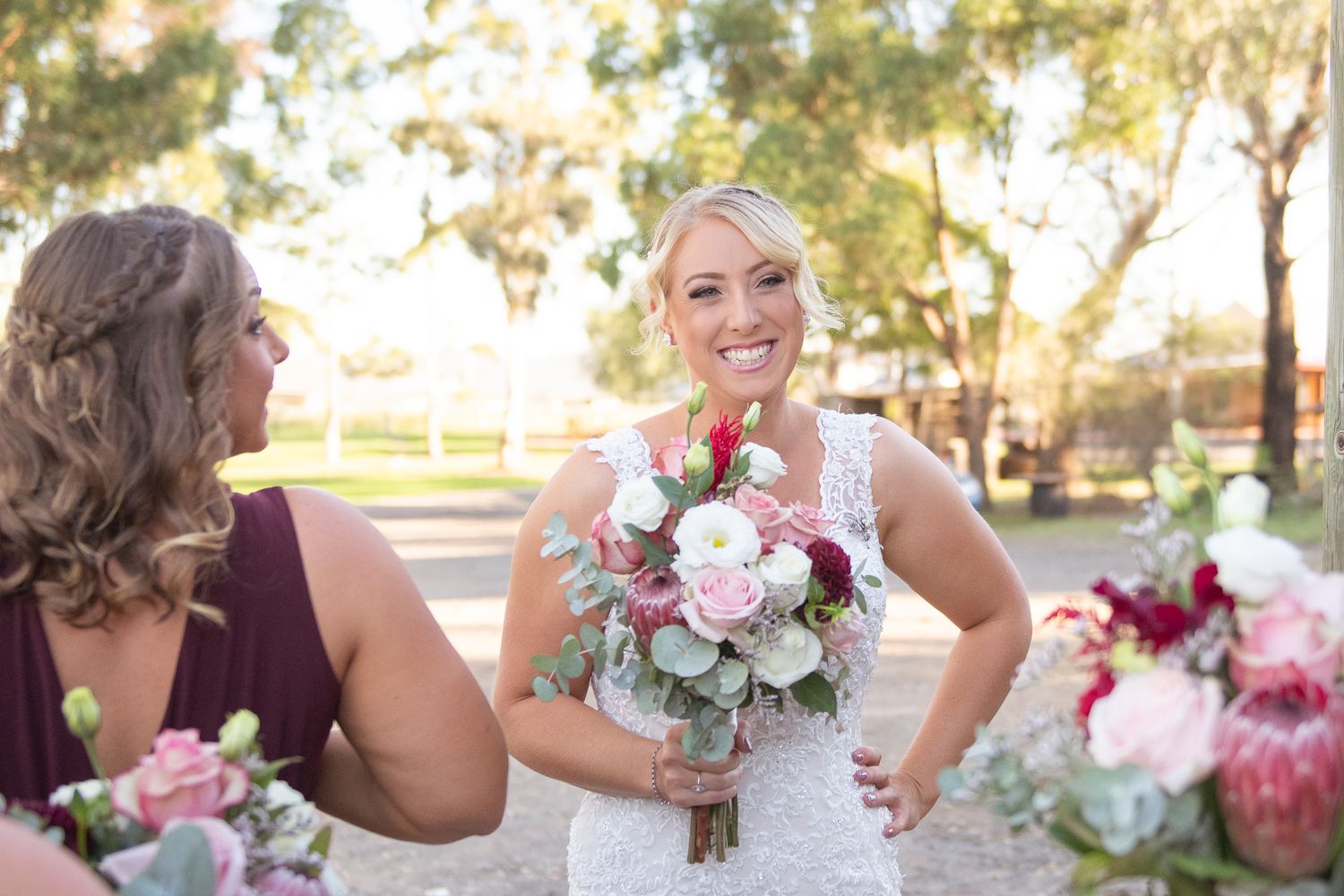Bride smiling before wedding ceremony with rustic flowers.