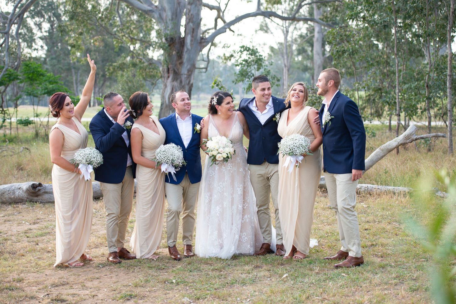 Wedding party lined up outdoors against natural Australian bush backdrop.