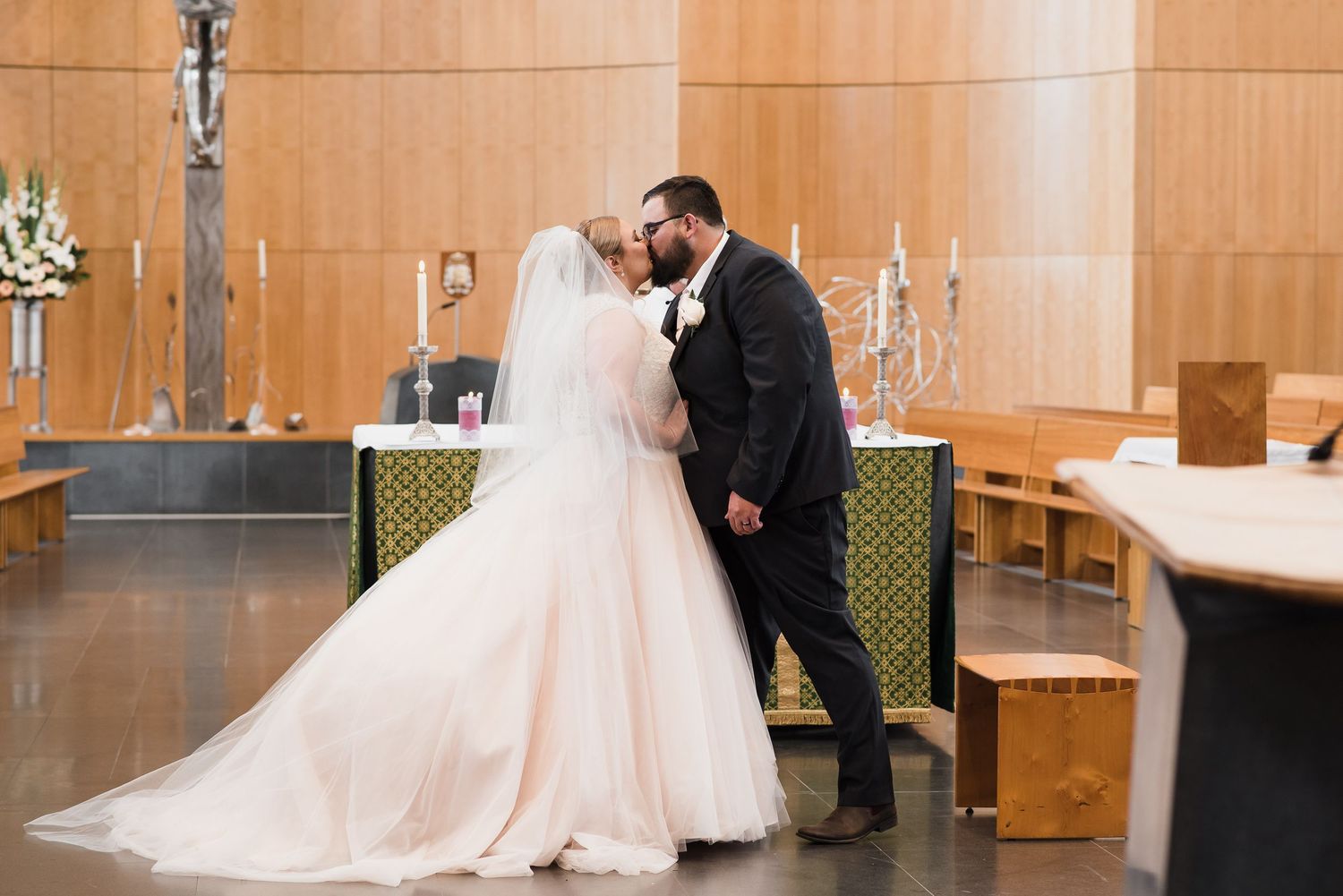 Bride and grooms first kiss during a church wedding.