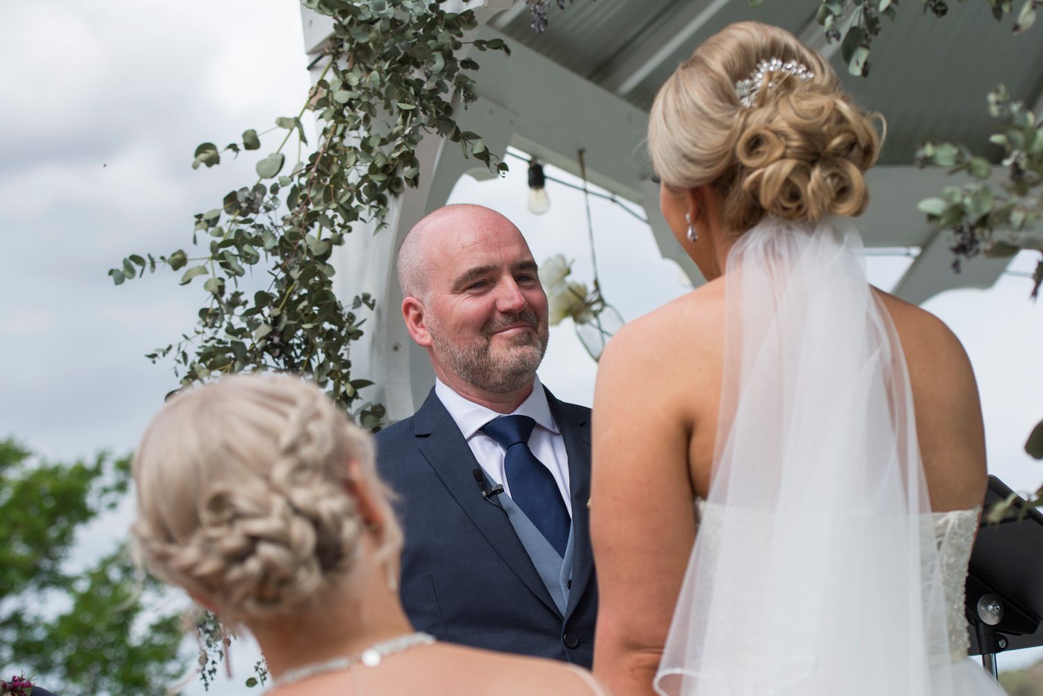 Bride and groom share intimate moments during their outdoor wedding ceremony.