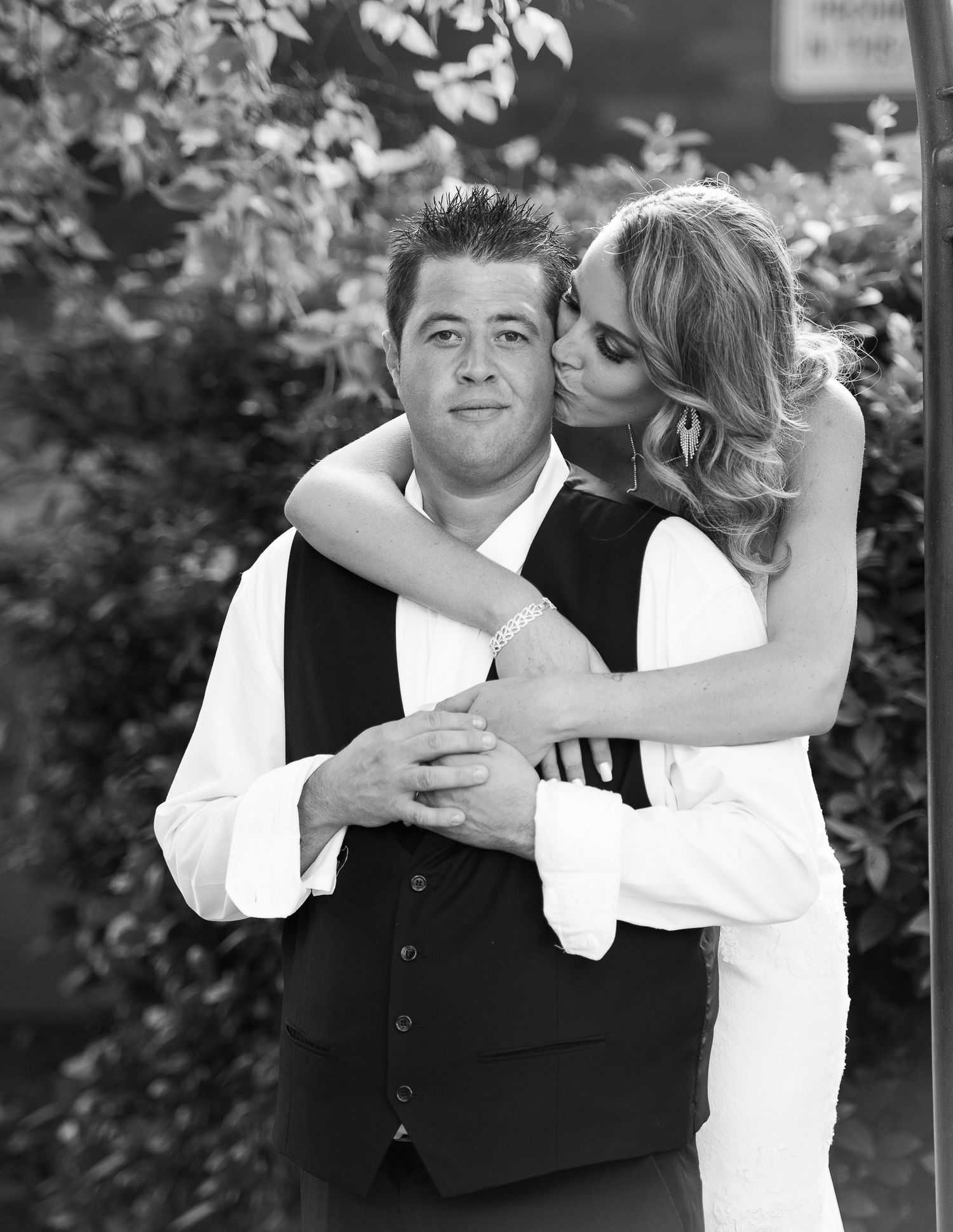 A couple in formal attire dances together outdoors in a series of black and white photos showing their joyful movements.