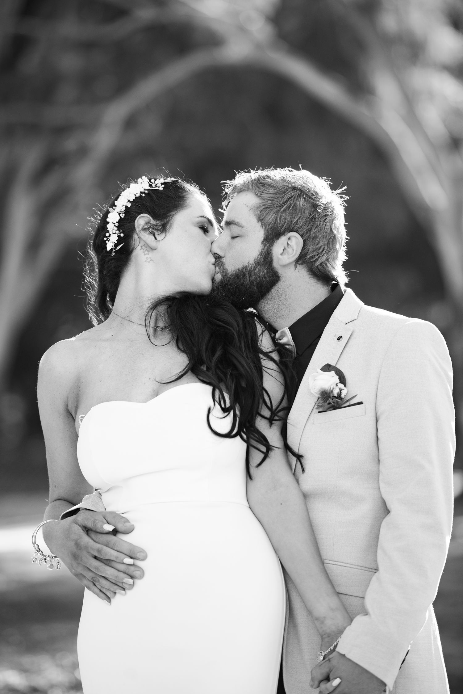 A romantic black and white photo sequence showing a couple embracing and kissing outdoors.