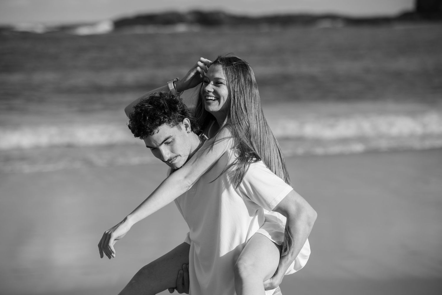 A series of black and white photographs showing couple having fun on beach in Kiama.