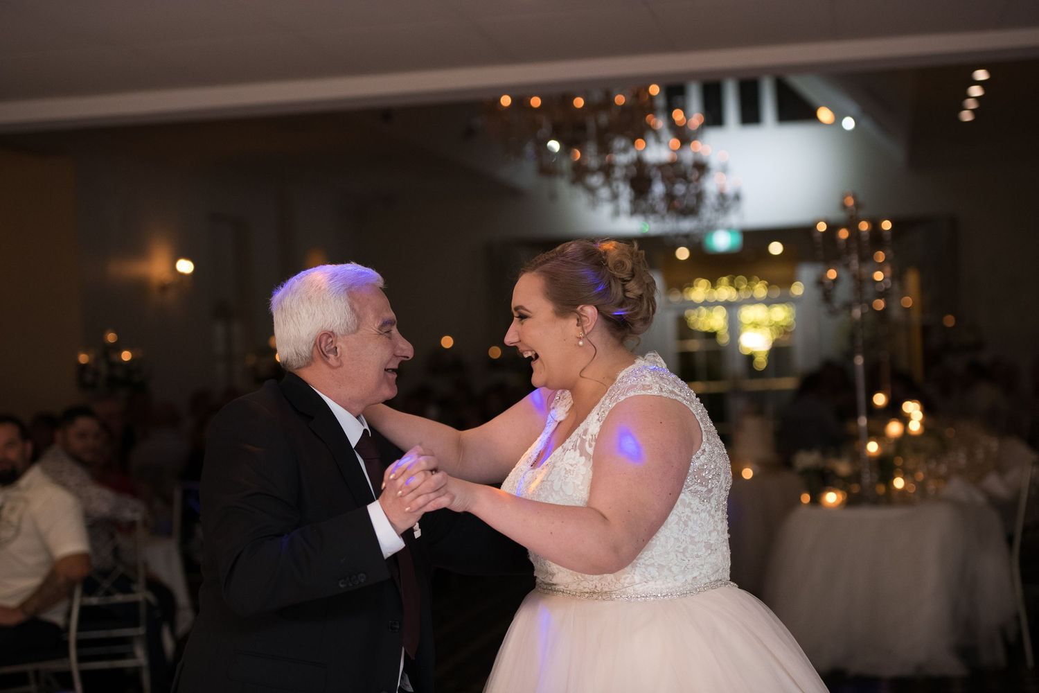 Dancing couples celebrate during evening wedding reception.