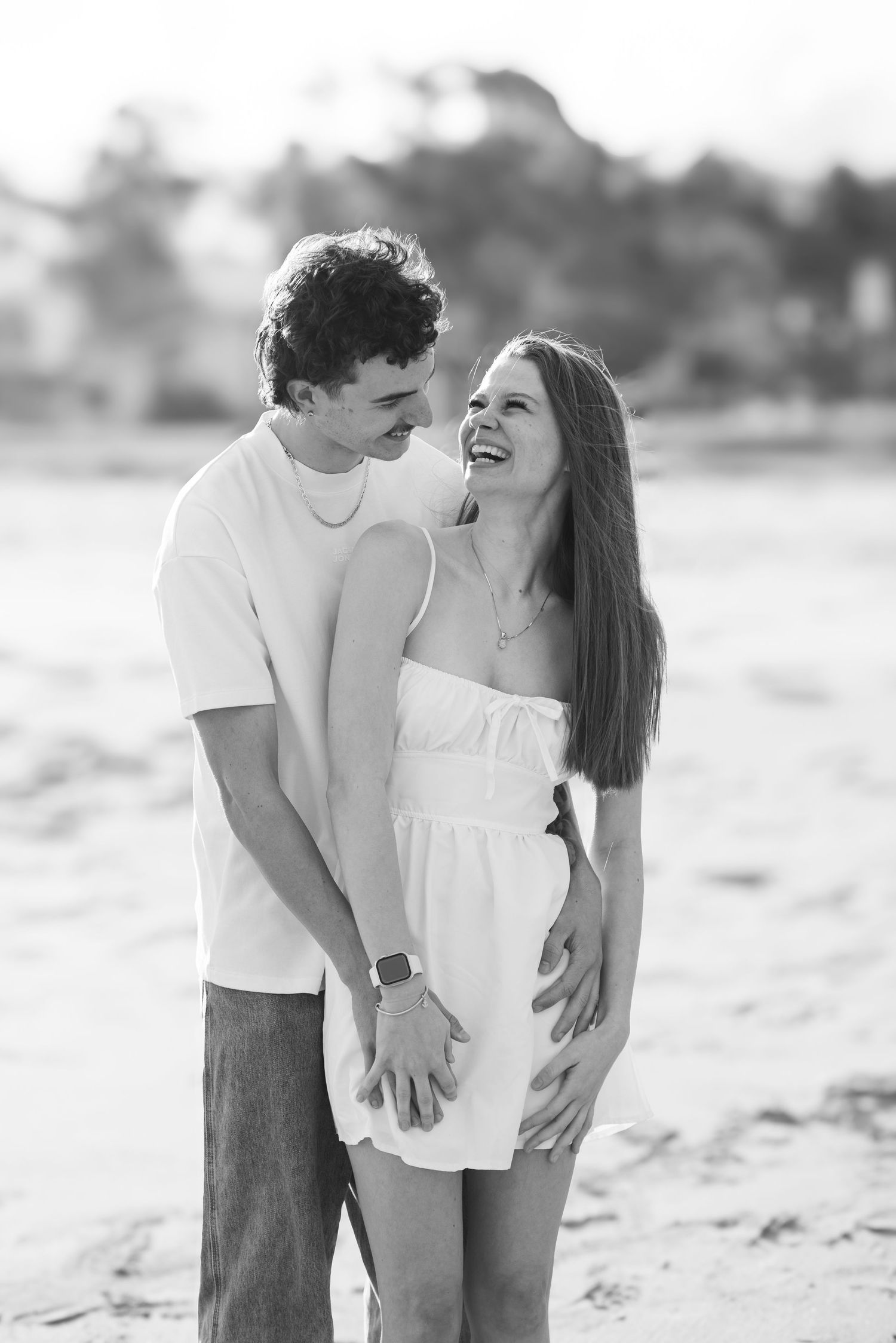 Couple laughing during their relaxed photo session on a beach in Kiama.