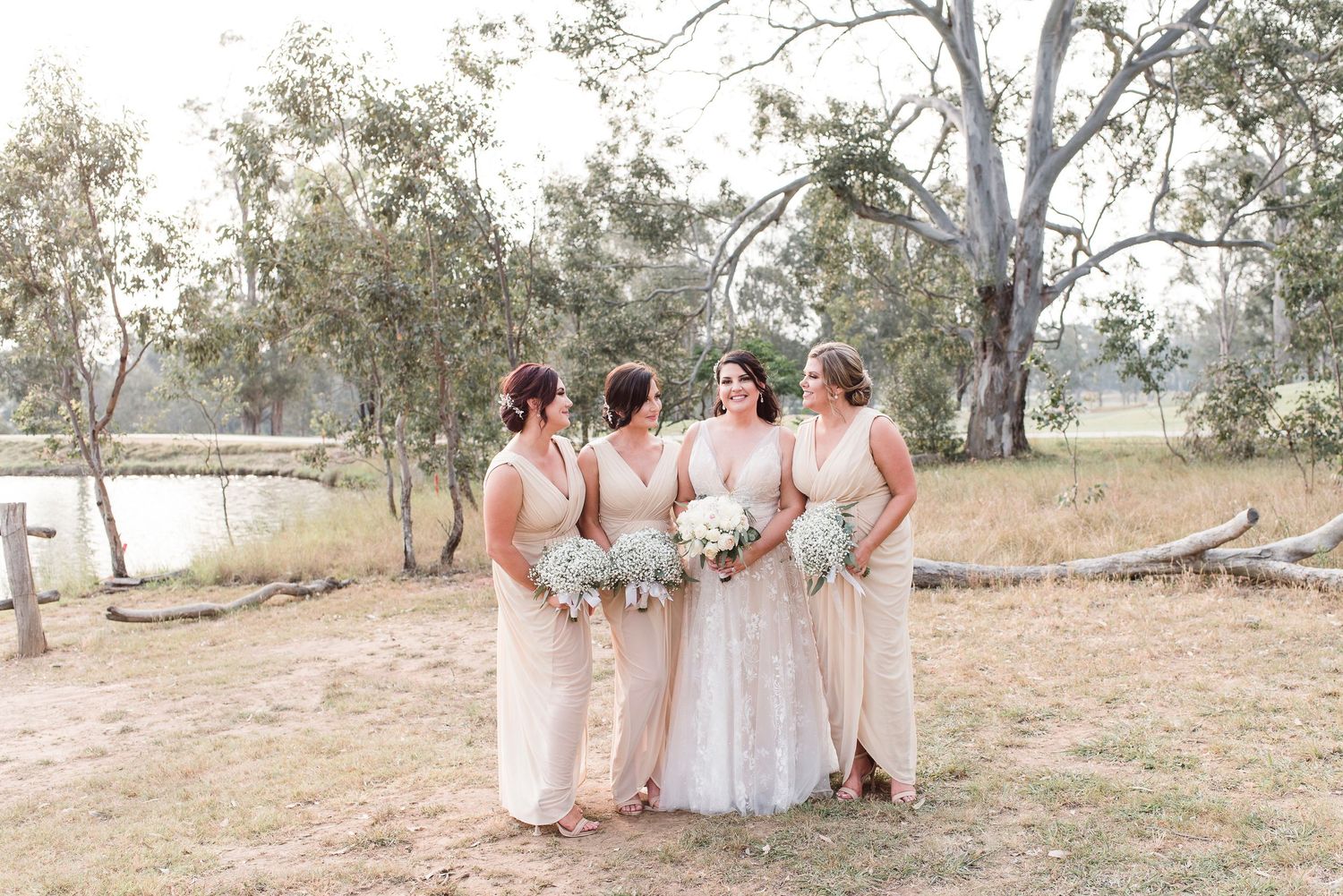 Wedding party posing in a natural outdoor setting with eucalyptus trees in the background.