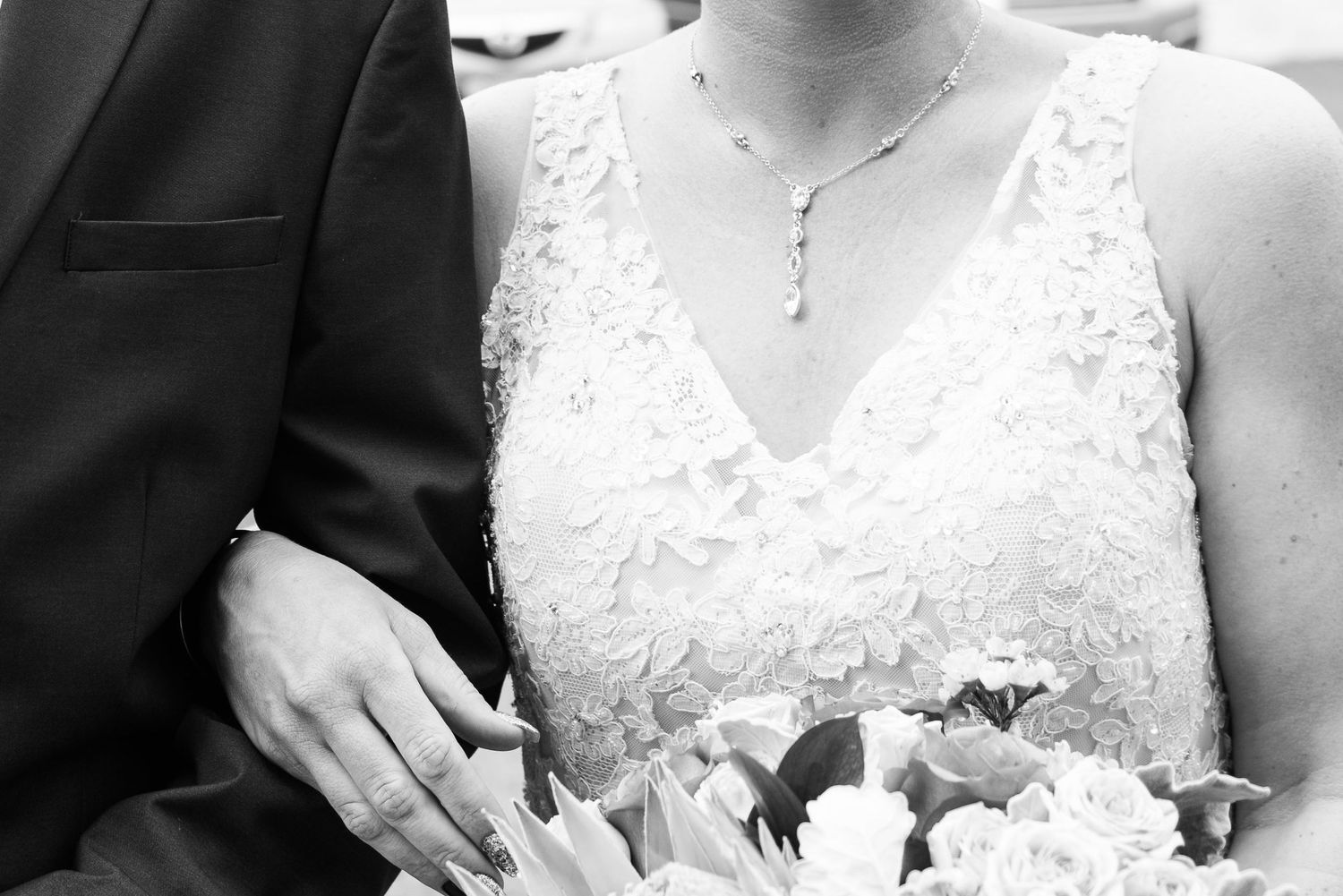 Detail shot of white lace wedding dress bodice with delicate floral patterns.