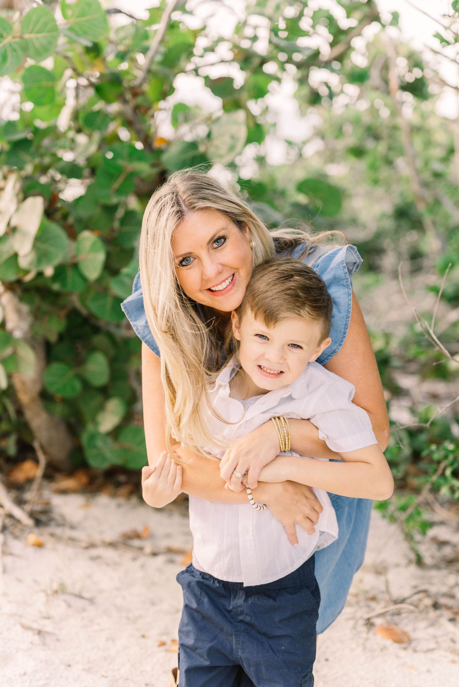 Lifestyle family portrait at Barefoot Beach with soft golden light.