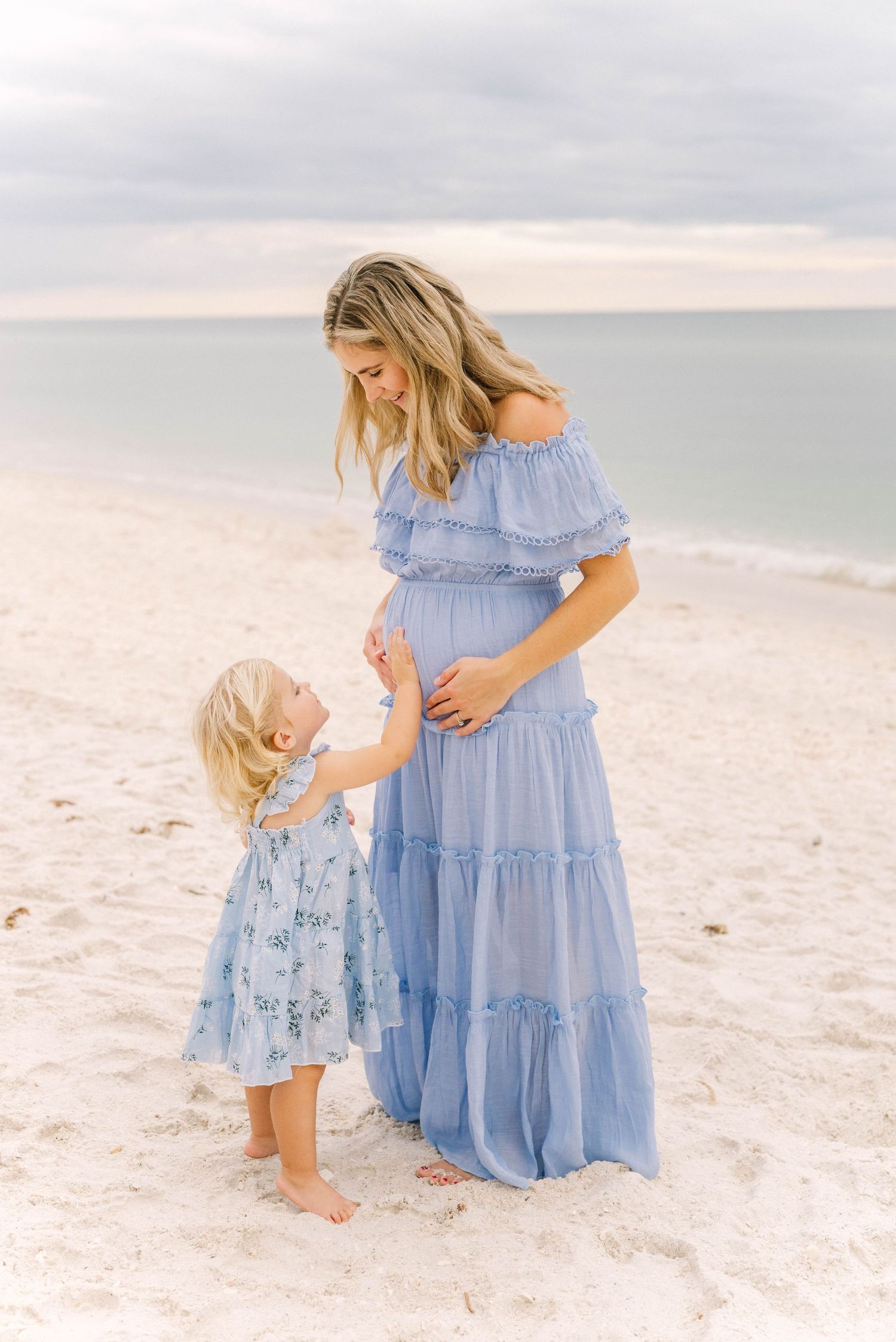 Lifestyle family portrait at Barefoot Beach with soft golden light.