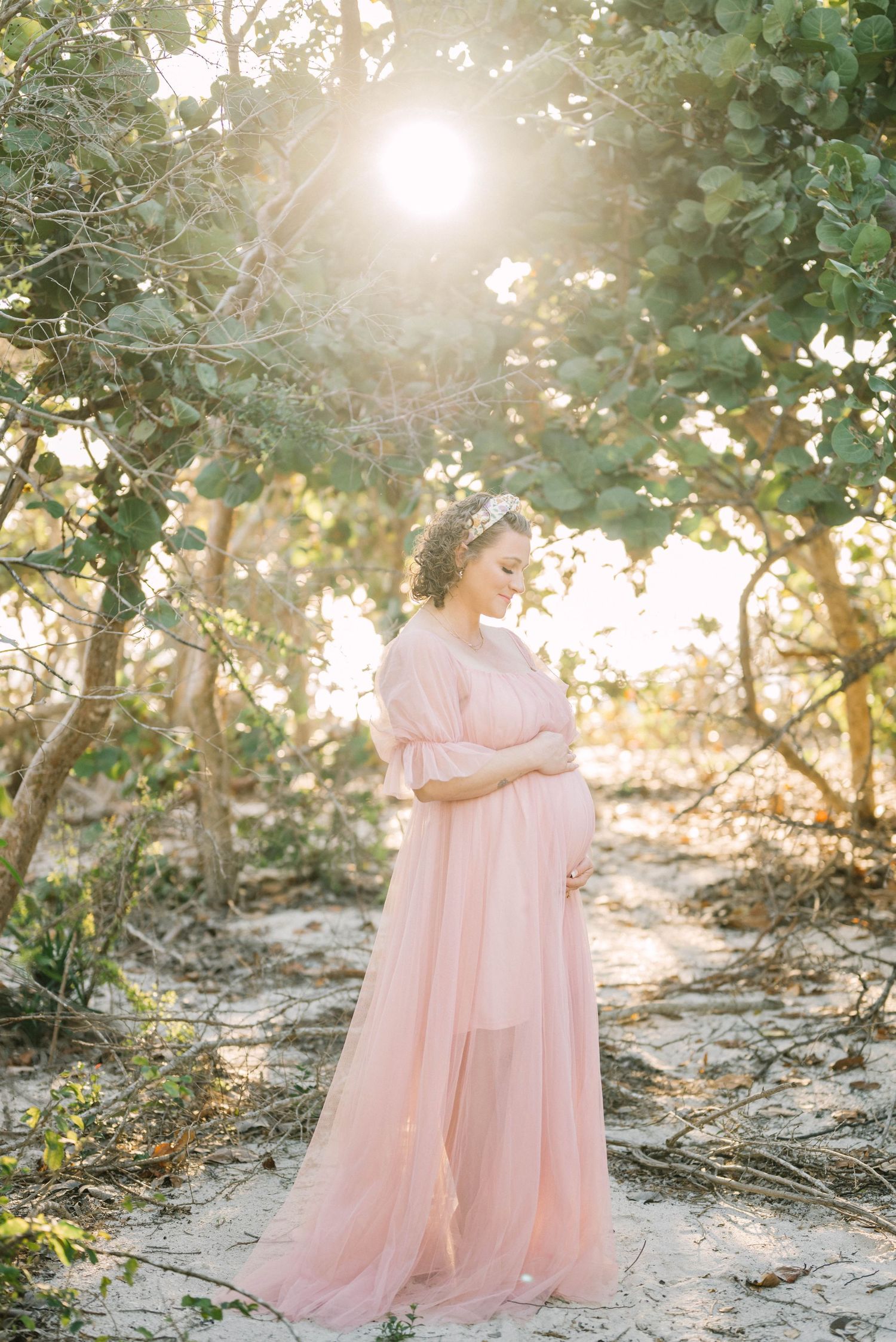 Lifestyle family portrait at Barefoot Beach with soft golden light.