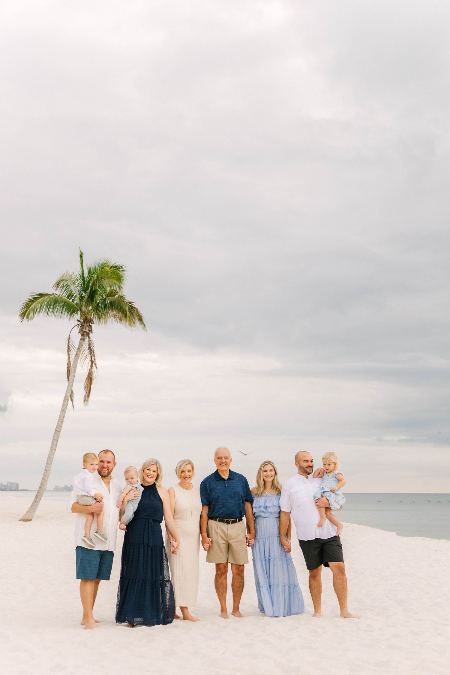 Lifestyle family portrait at Barefoot Beach with soft golden light.