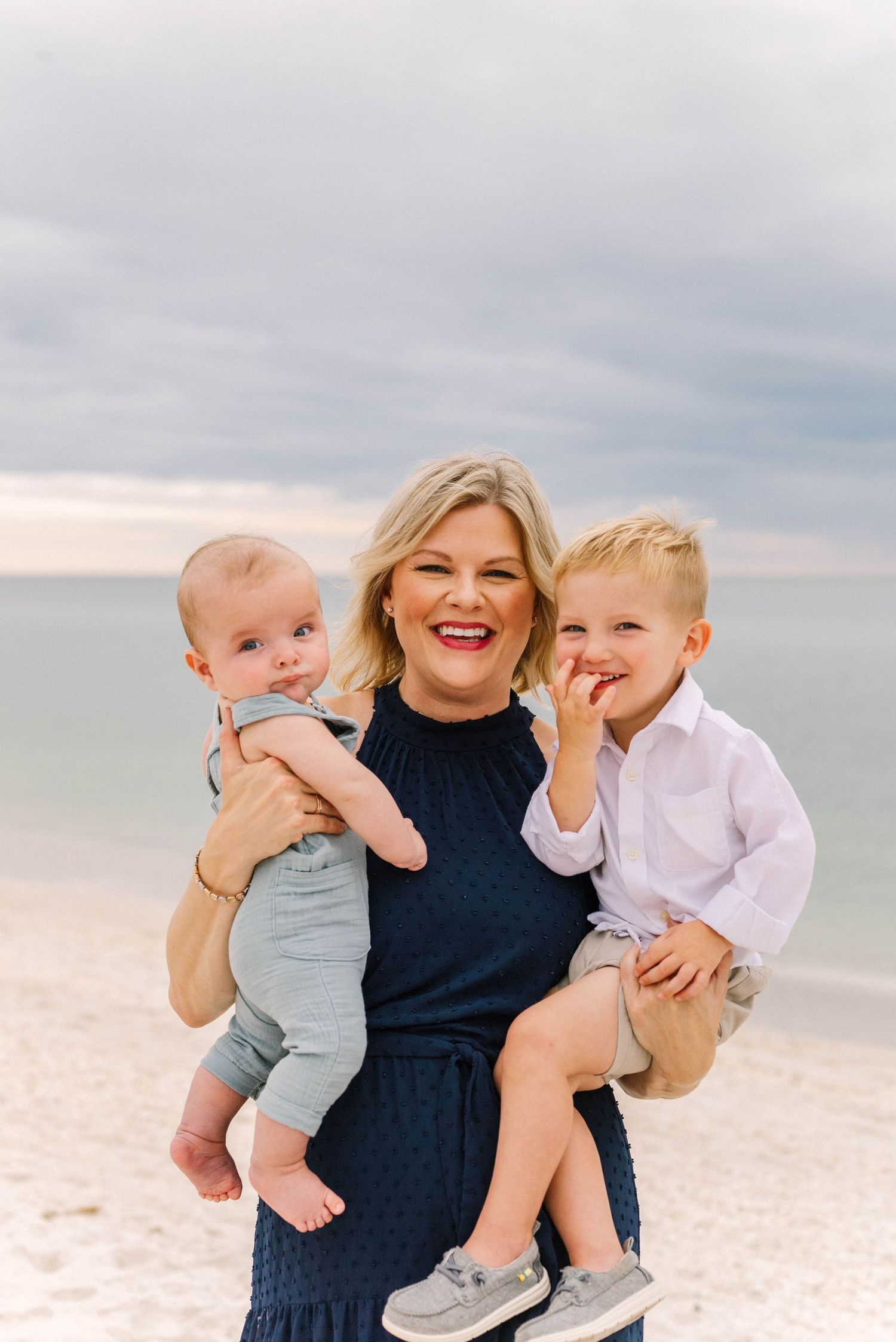 Lifestyle family portrait at Barefoot Beach with soft golden light.