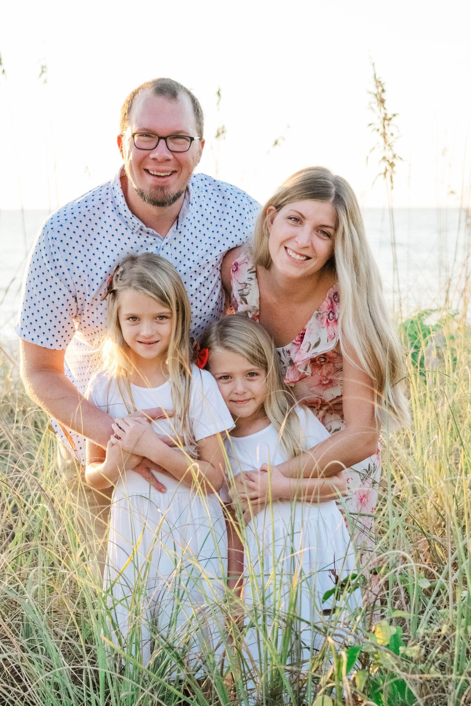 Lifestyle family portrait at Barefoot Beach with soft golden light.