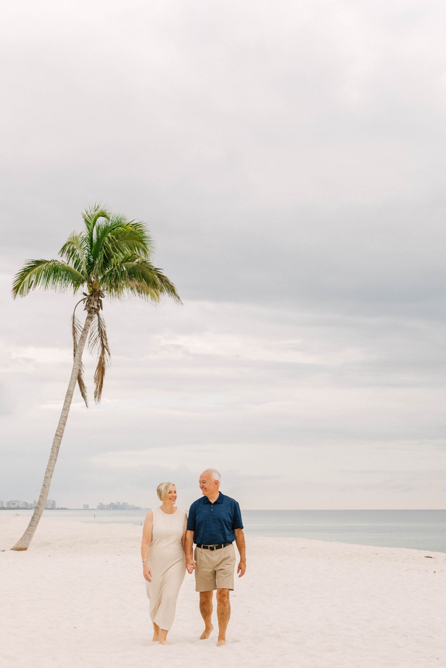 Lifestyle family portrait at Barefoot Beach with soft golden light.