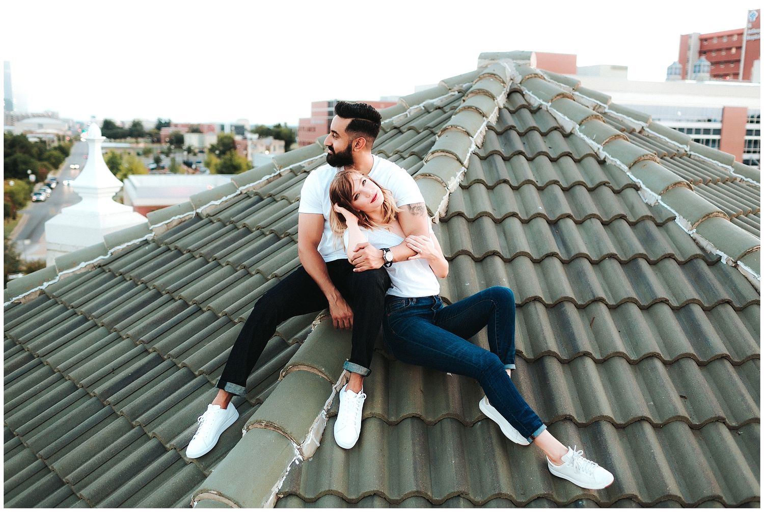 Engagement photo session for a couple posing on a rooftop in downtown Oklahoma City Midtown.