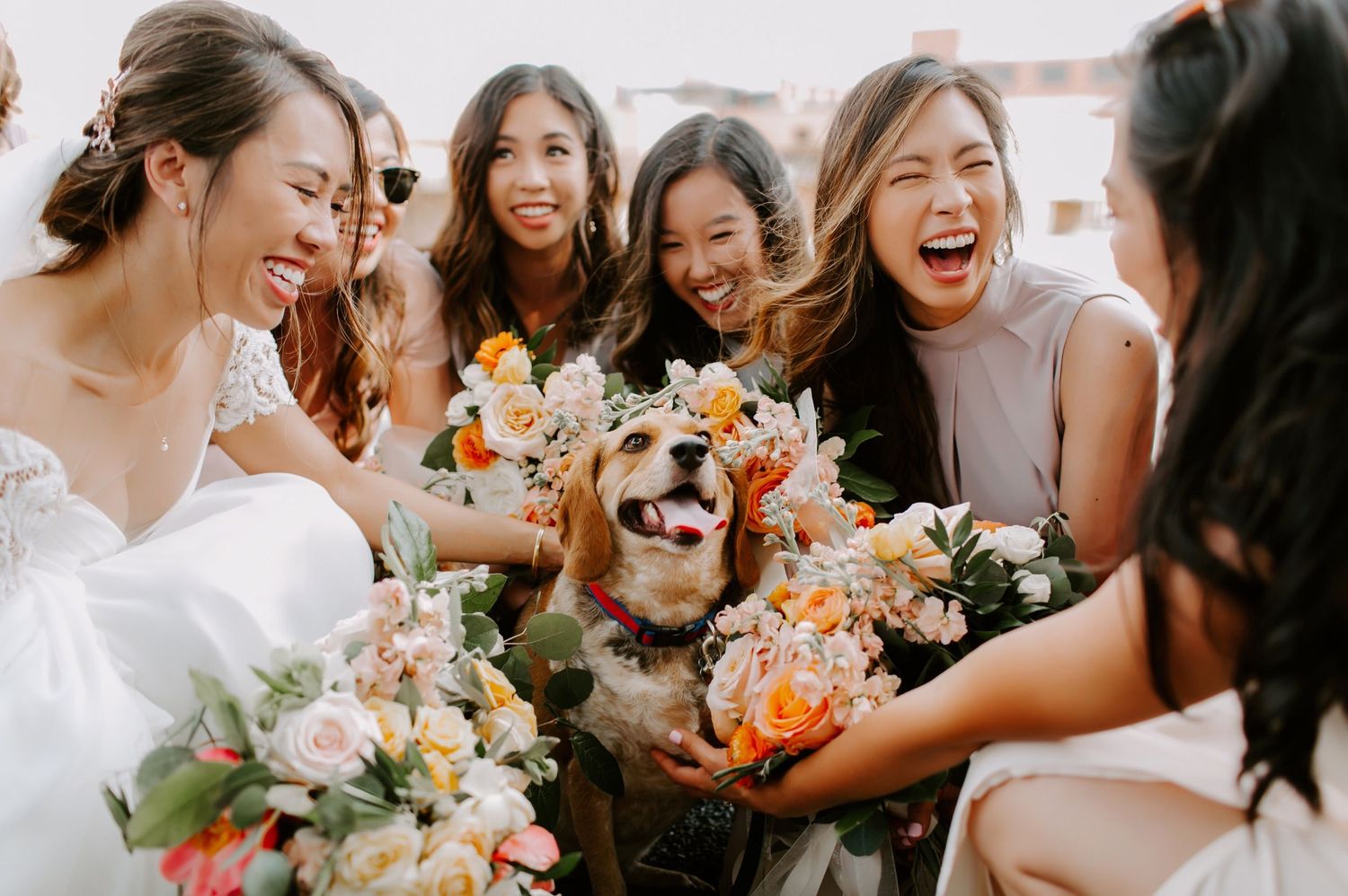 Candid moment of a bride and her bridesmaids using their wedding bouquets to create a flower ring around the flower girl at OKC wedding