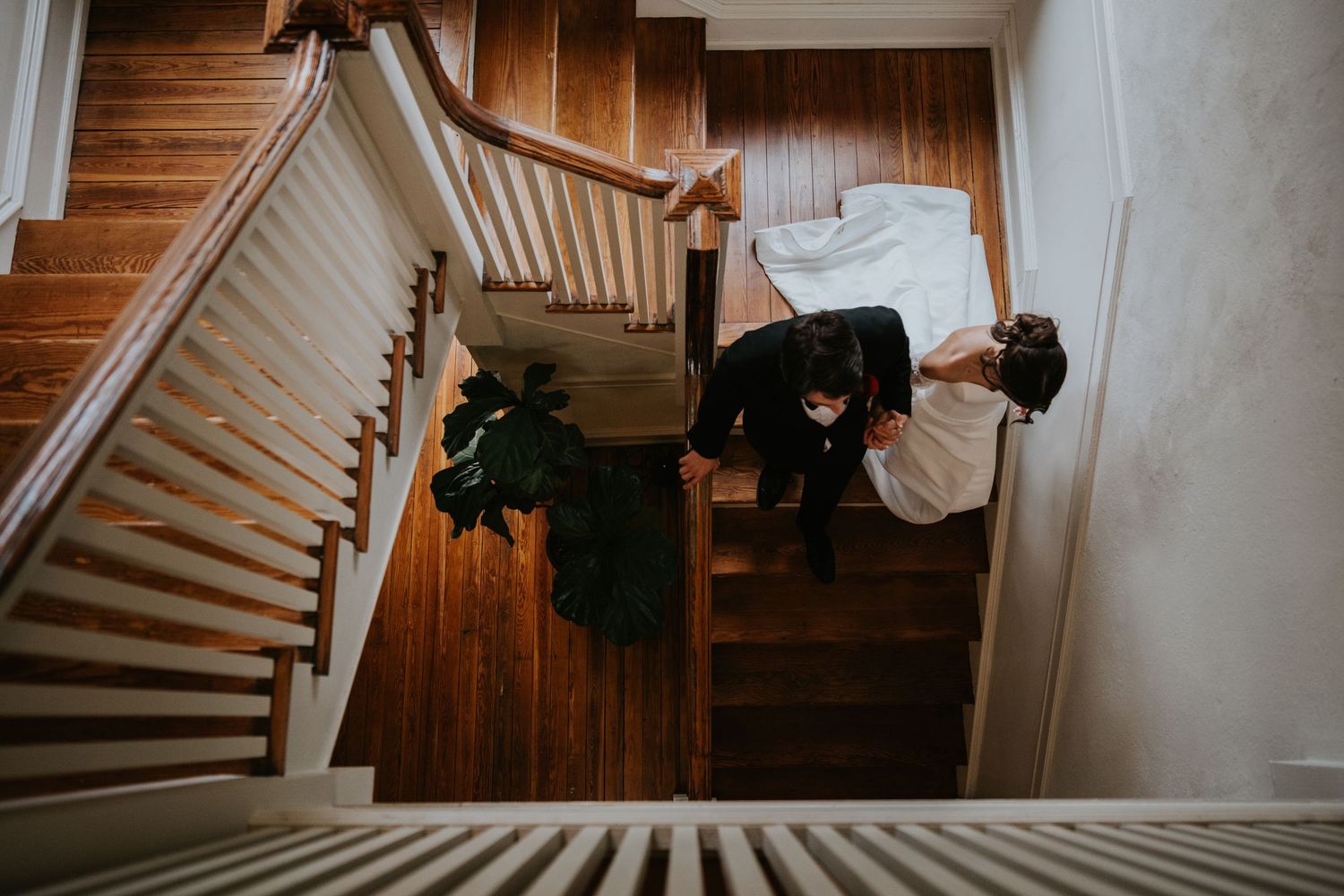 A creative overhead view of a couple posing on wooden stairs during their wedding photoshoot.