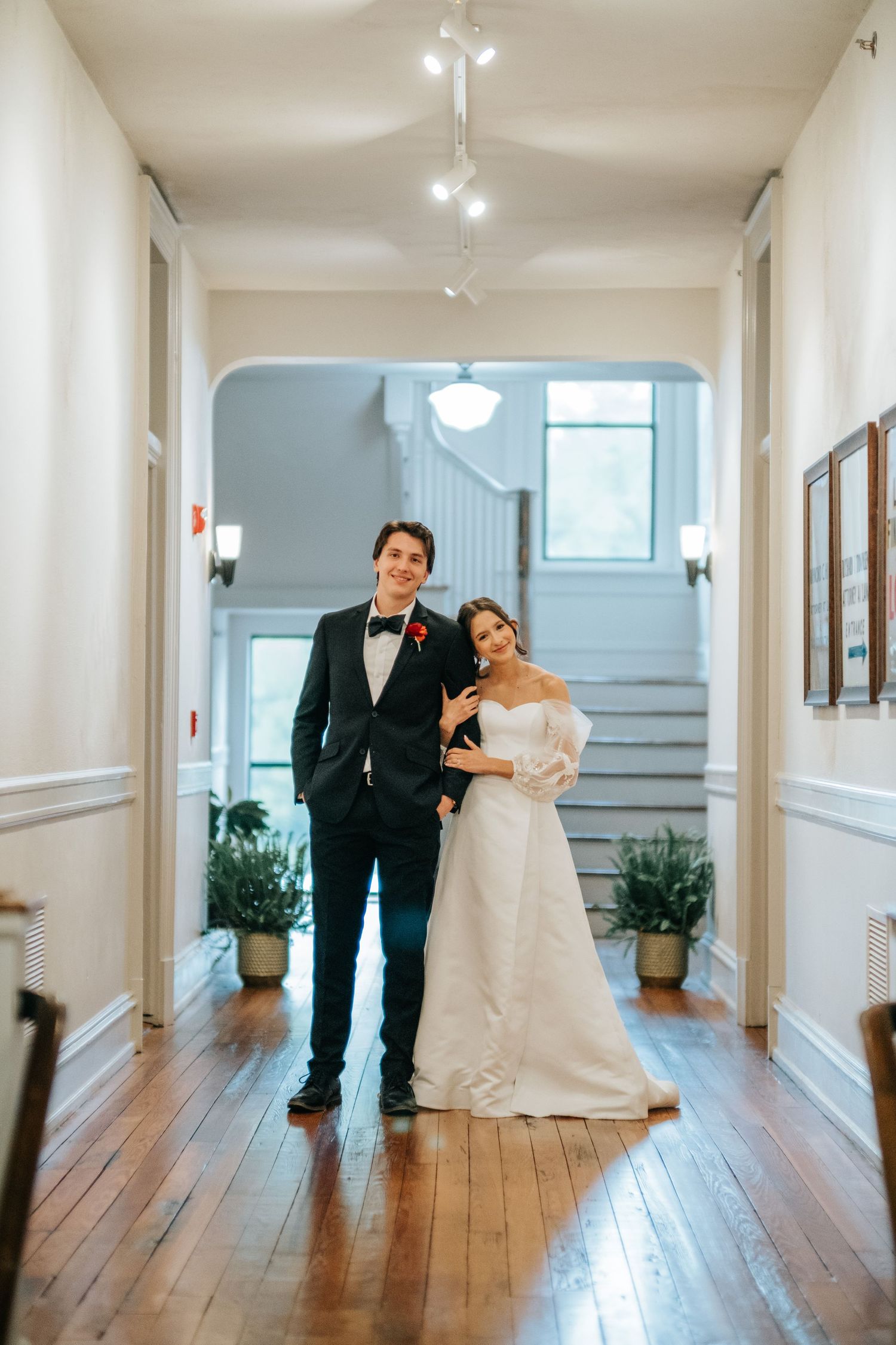 A sequence of photos showing a couple walking and posing in a bright white hallway with hardwood floors.