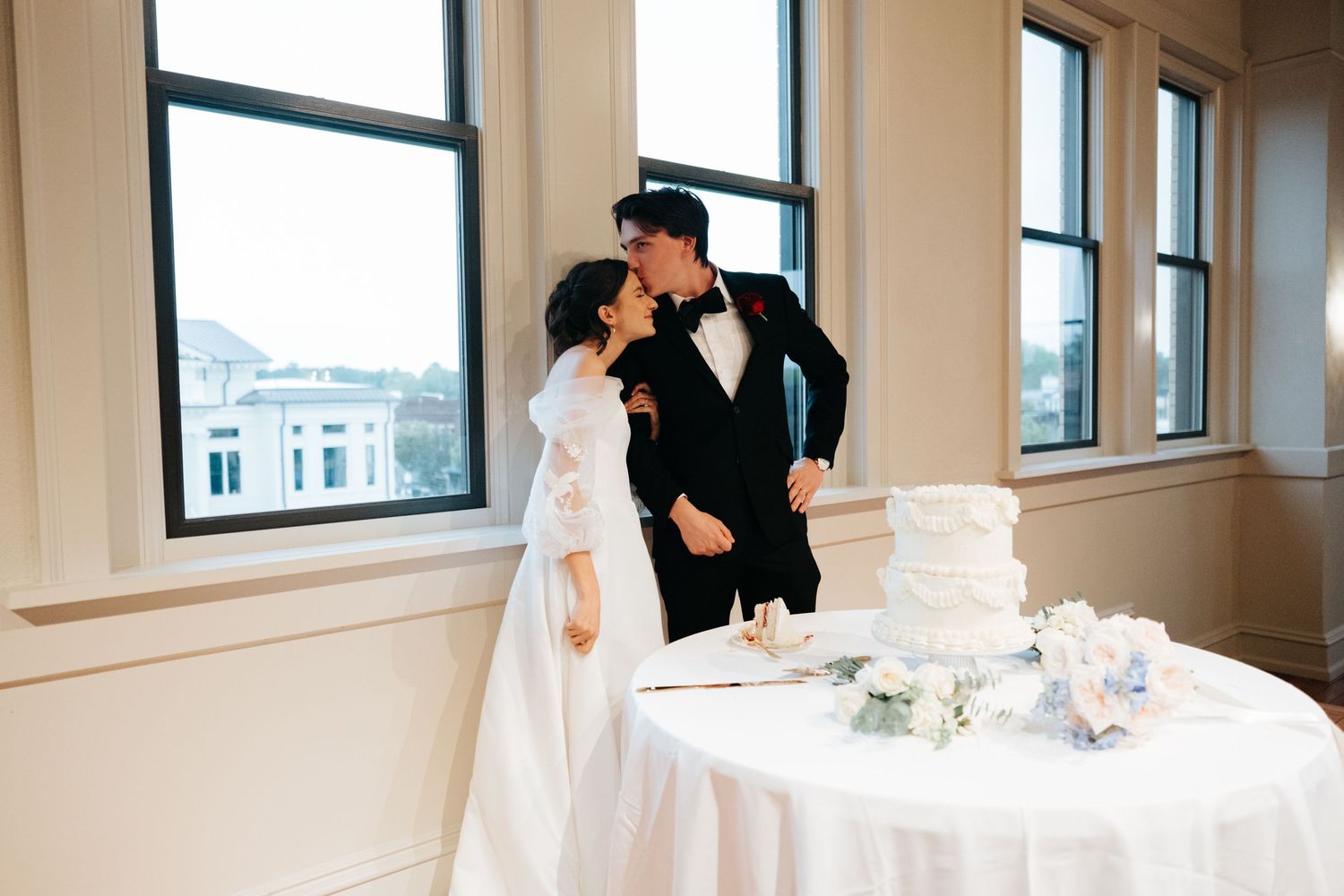Modern venue interior with large windows, natural light, and elegant table settings for a formal event.