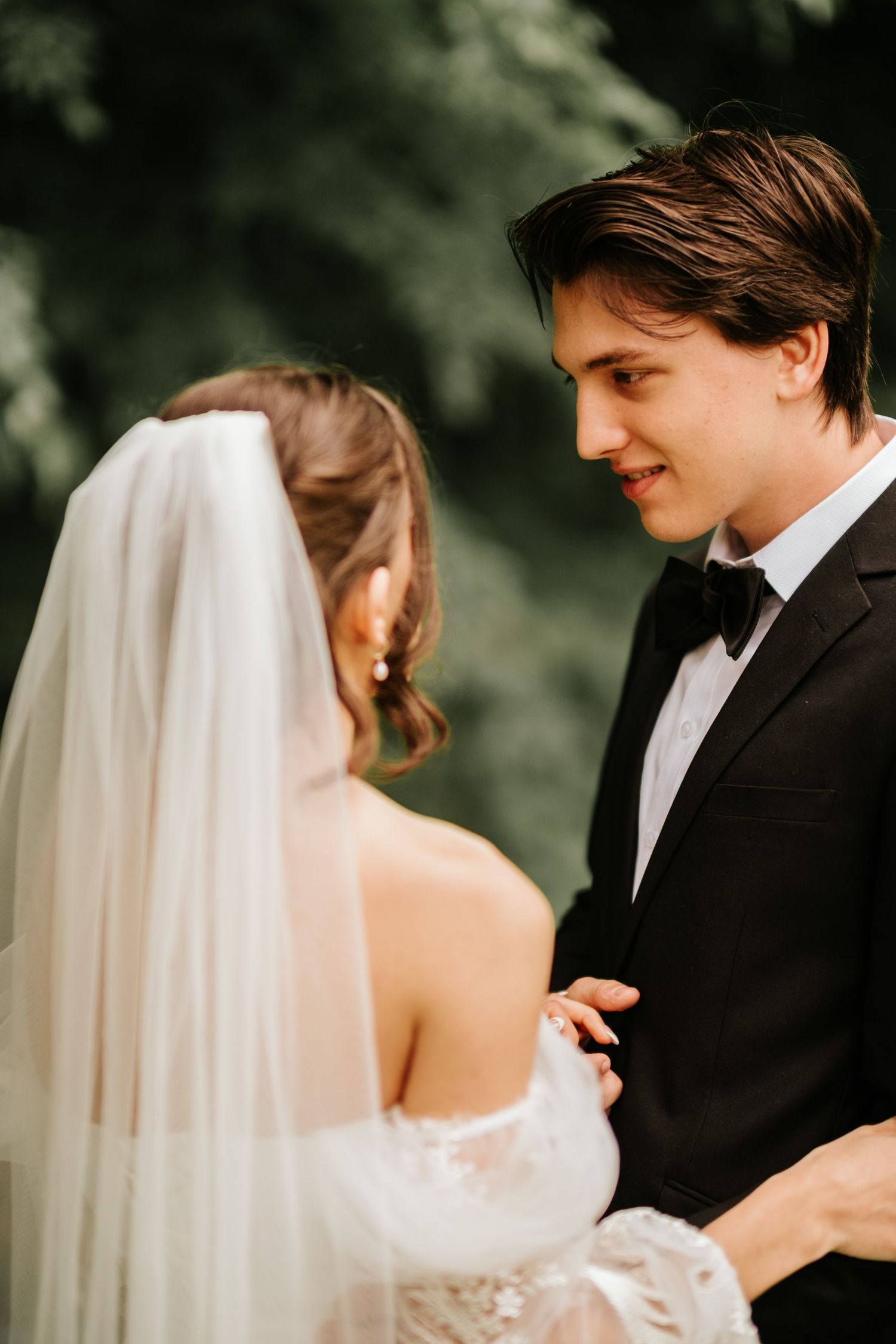 Close-up view of newlyweds sharing an intimate moment with a flowing white veil.