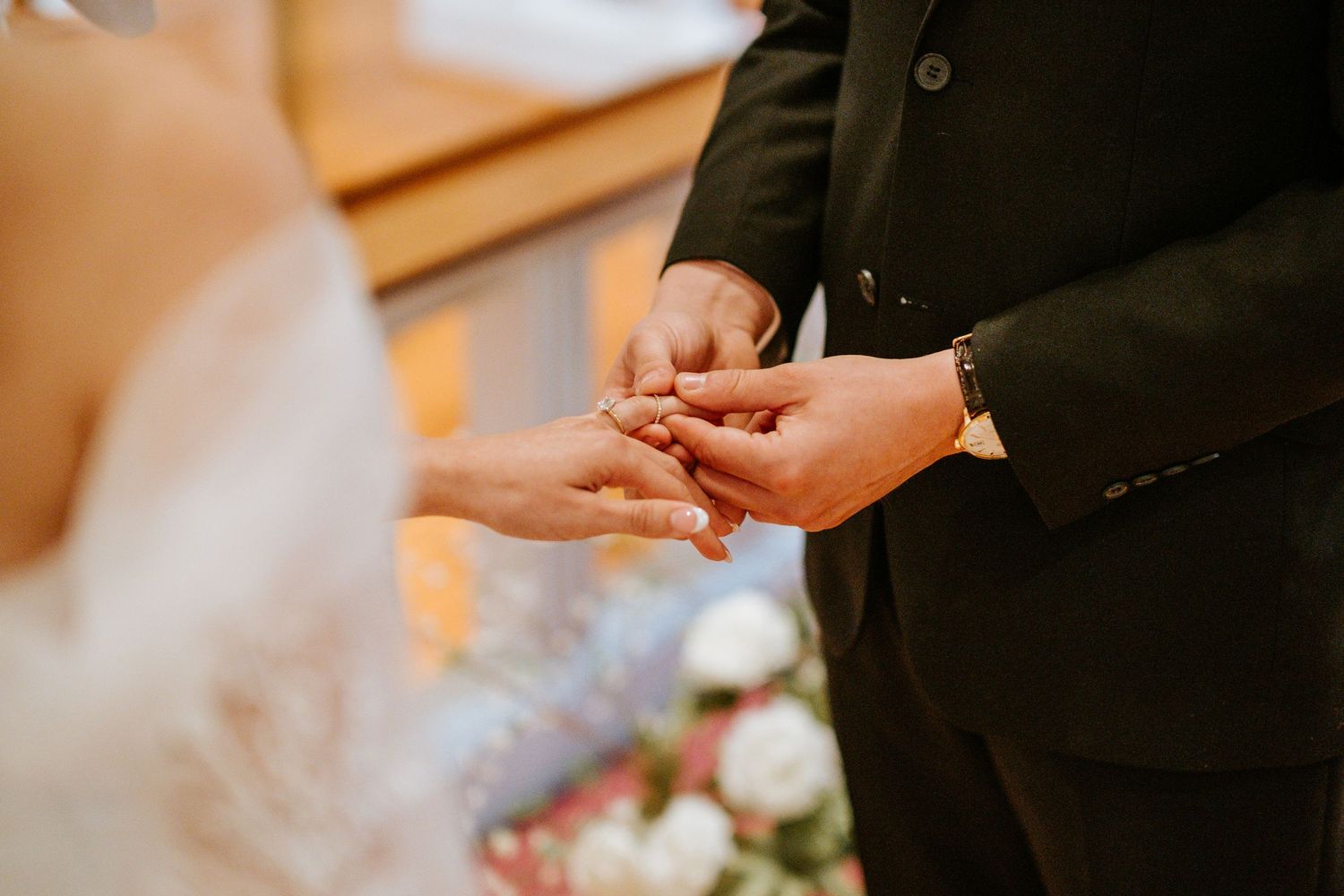 Two hands exchanging wedding rings during an intimate ceremony moment.