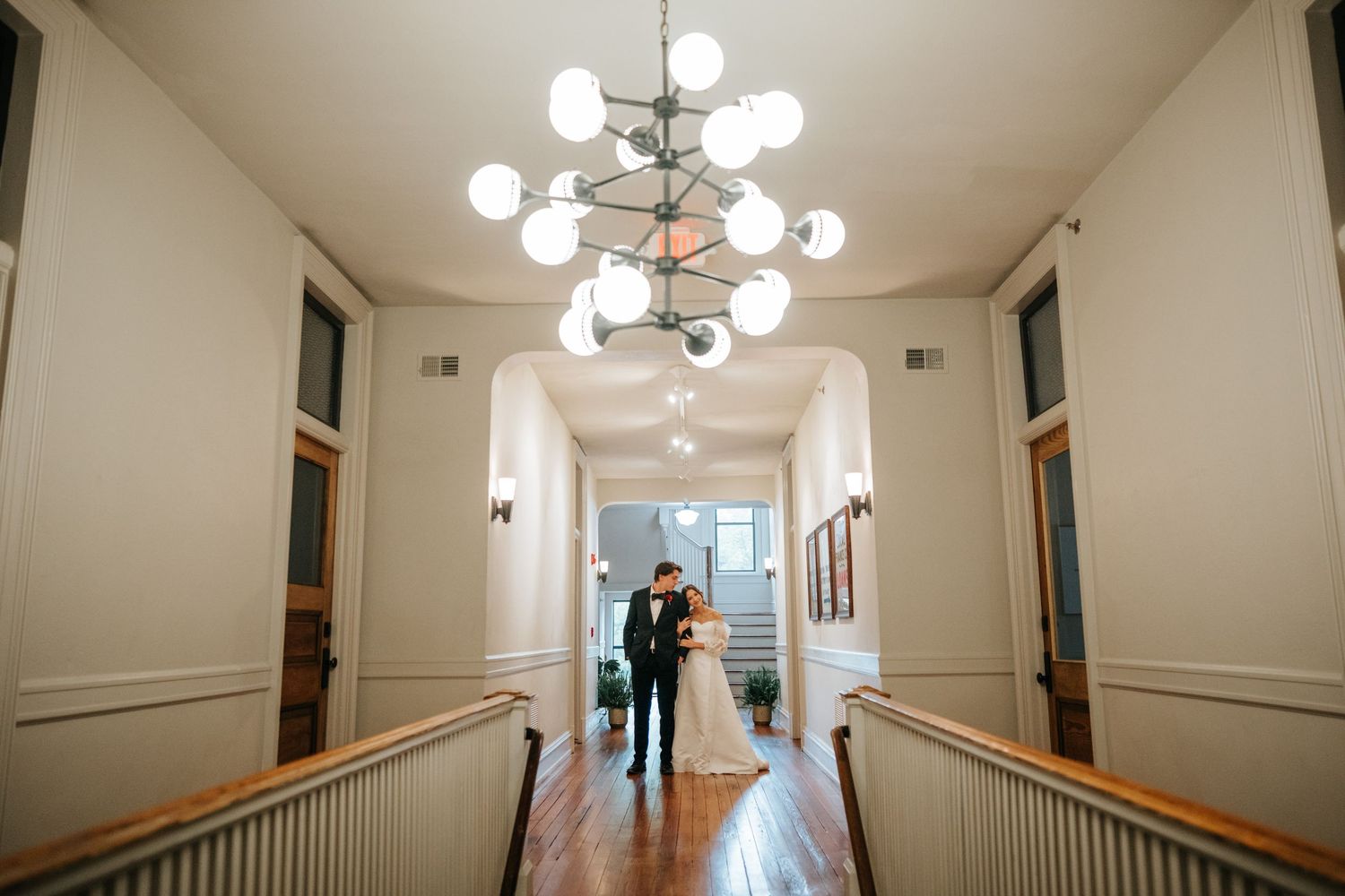 Long hallway with modern light fixtures and white wainscoting details.