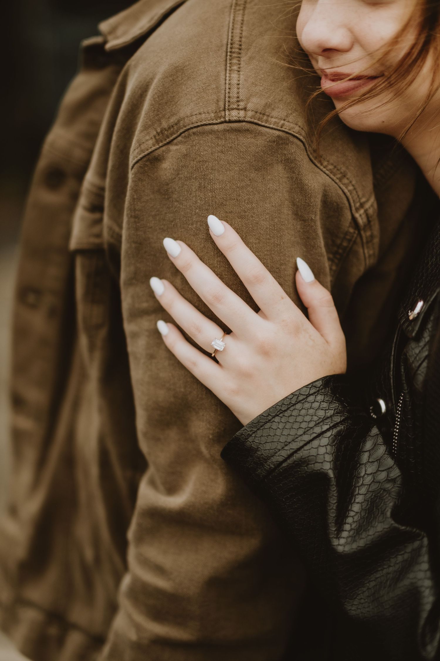 A close-up series showing hands wearing a black knit glove embracing someone in a brown jacket.