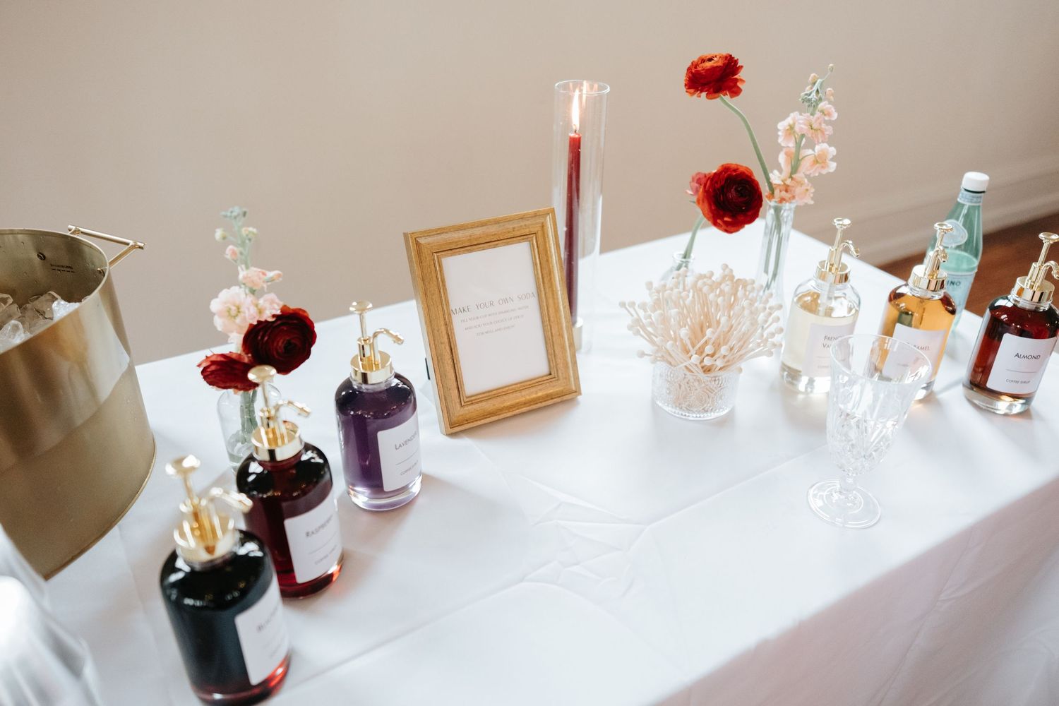 A row of elegant glass vases and decorative items displayed on a white shelf with red floral accents.