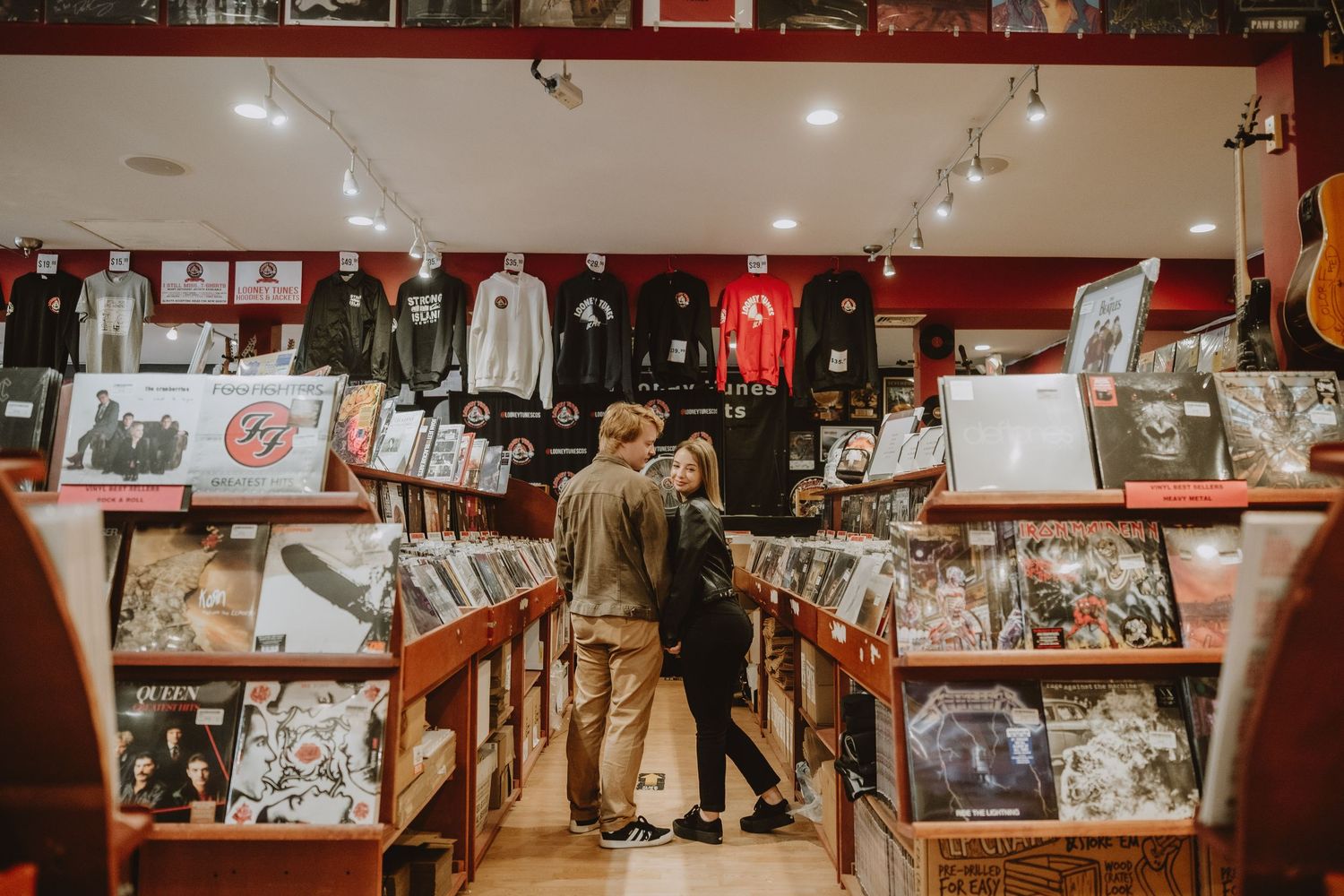 Vintage sports memorabilia and photographs line the walls of a dimly lit red room with track lighting.
