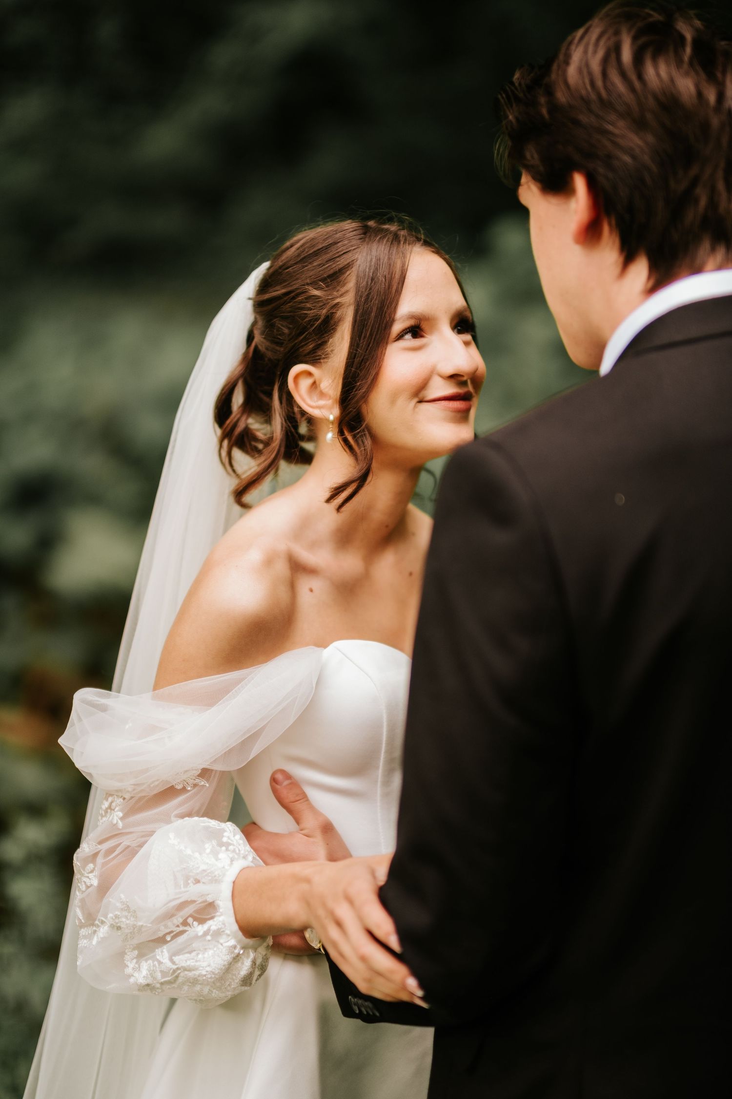 Tender wedding moment captured between bride and groom with soft natural lighting.