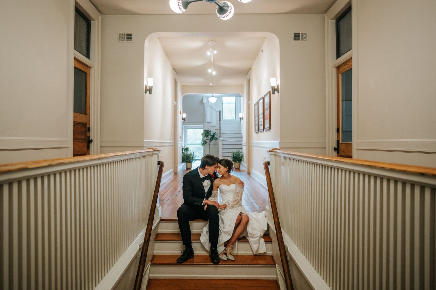 Bright interior corridor with globe light fixtures and white paneled walls.