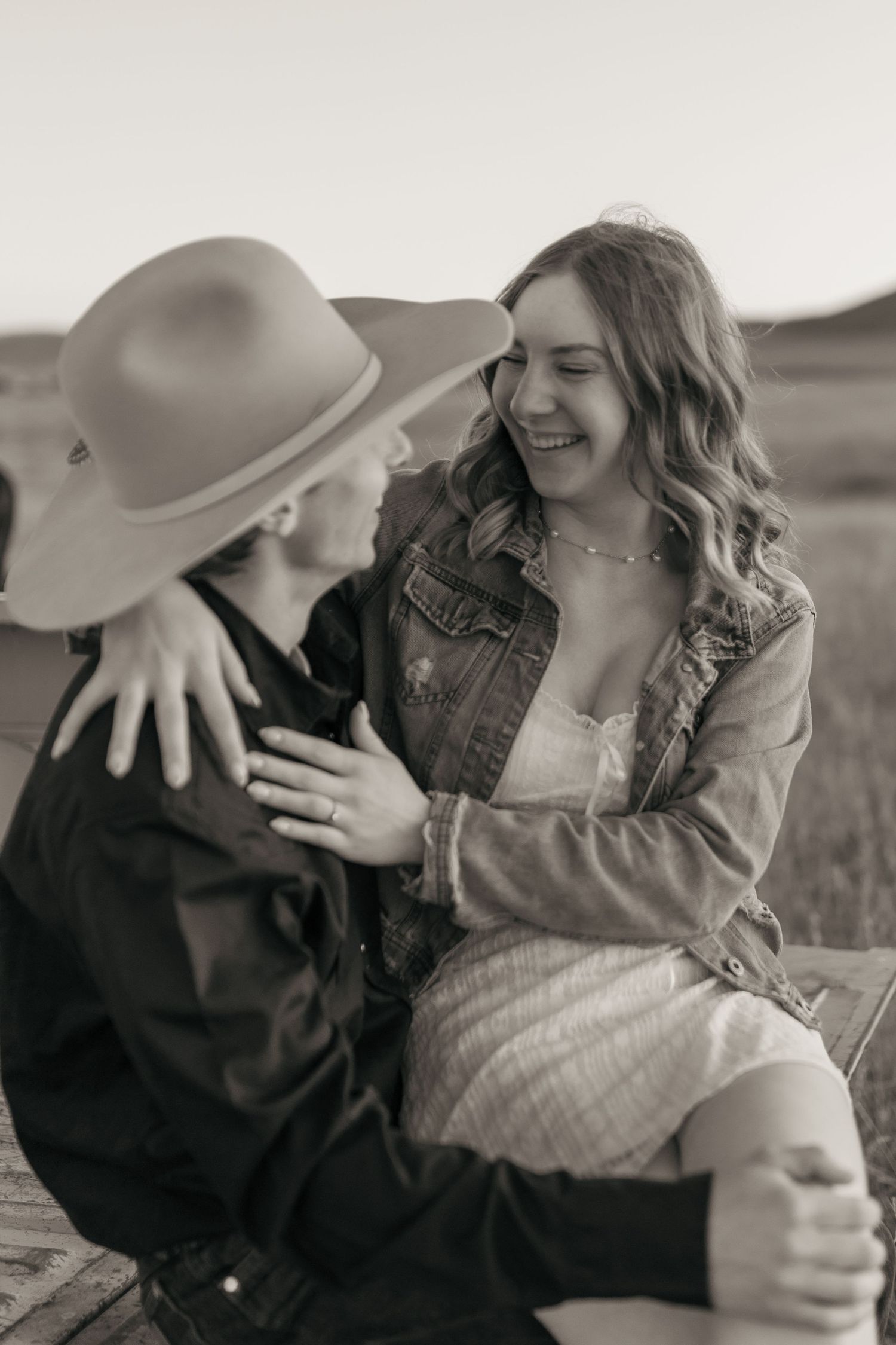 Candid black and white photos show joyful laughter and connection in a countryside setting.