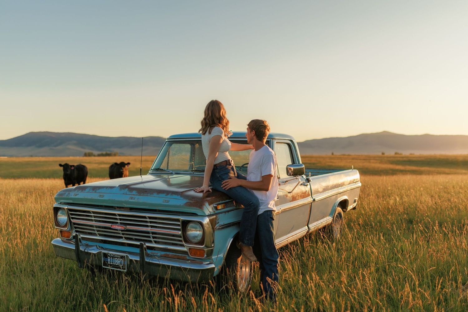 Romantic countryside photoshoot with vintage pickup truck in golden evening light.