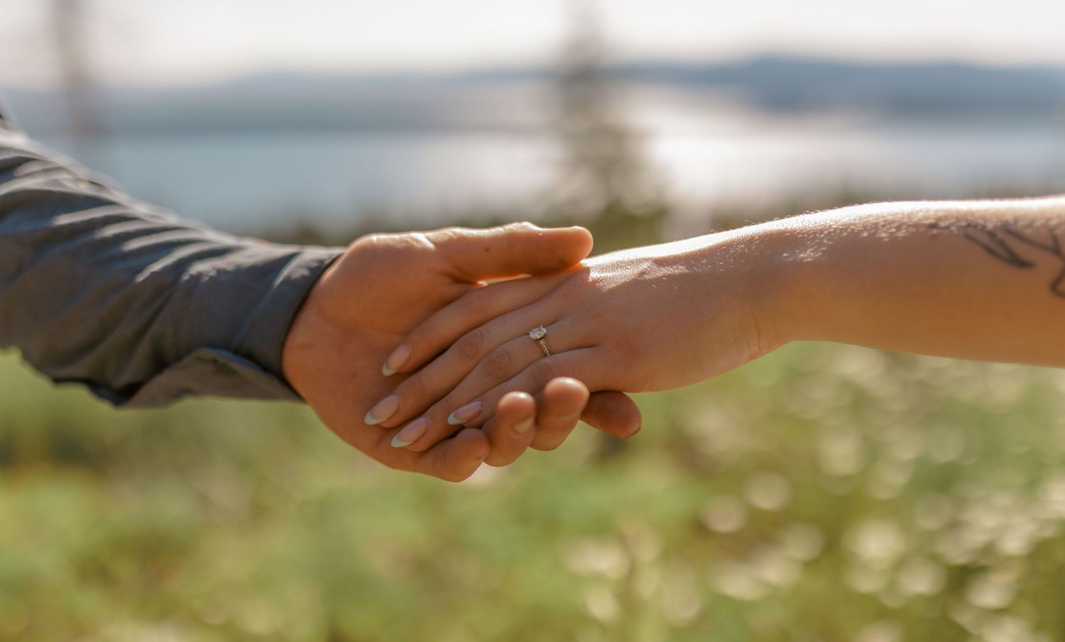 Close-up of hands touching tenderly during an outdoor photoshoot.