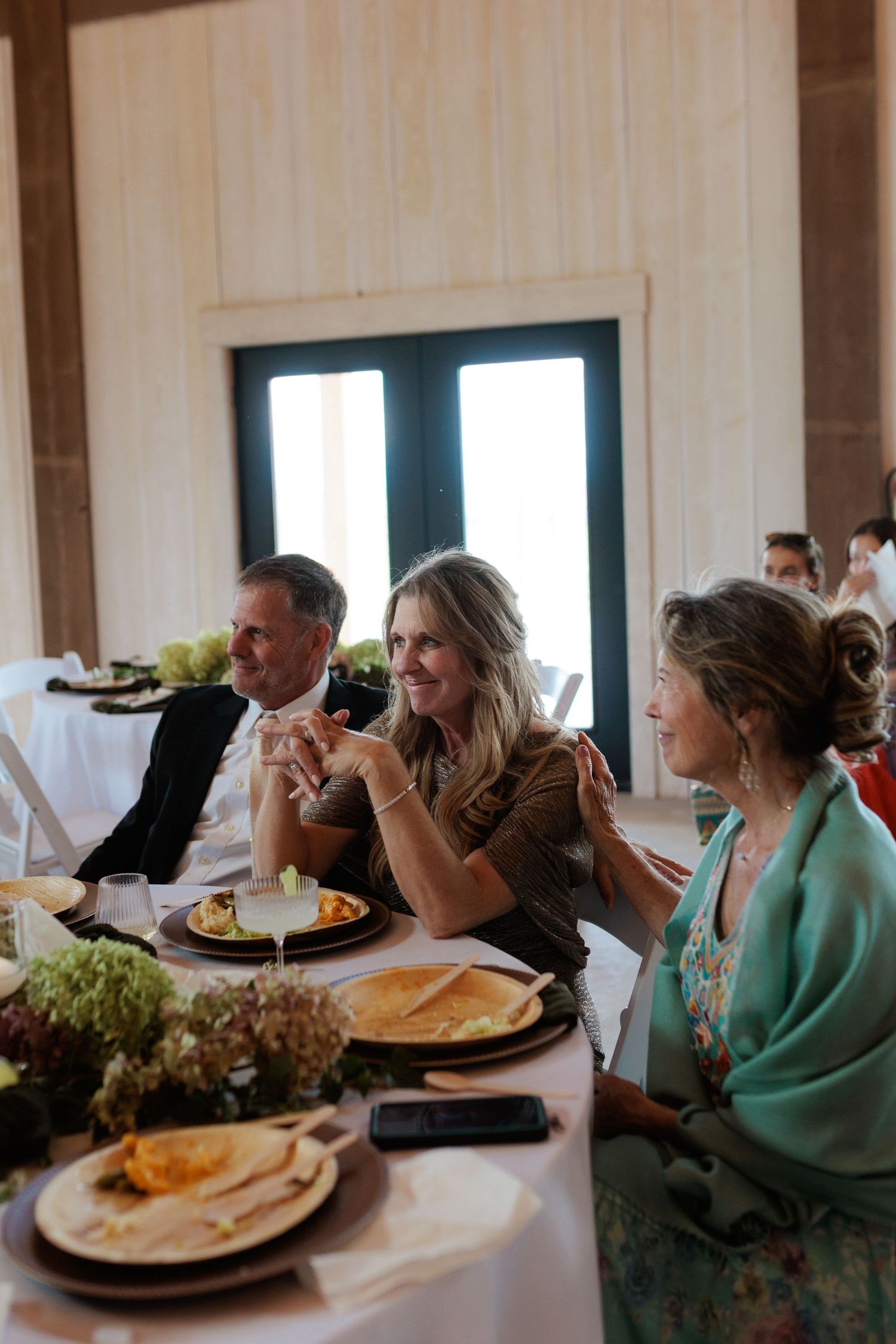 Parents of the groom getting emotional while listening to a speech as grandma of the groom comforts mother of the groom at Montana wedding