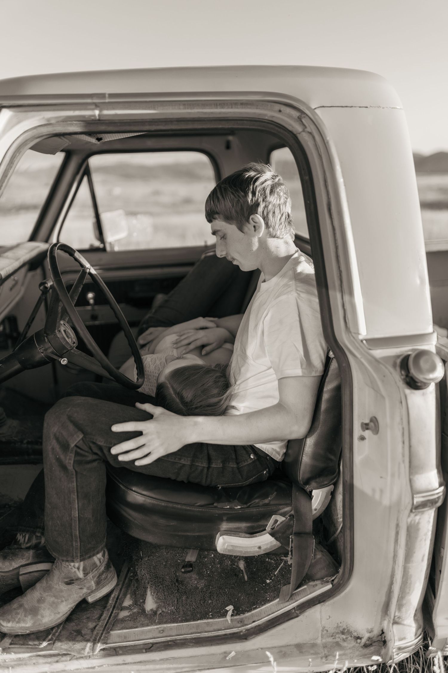 Black and white interior car scene with vintage styling and moody lighting.