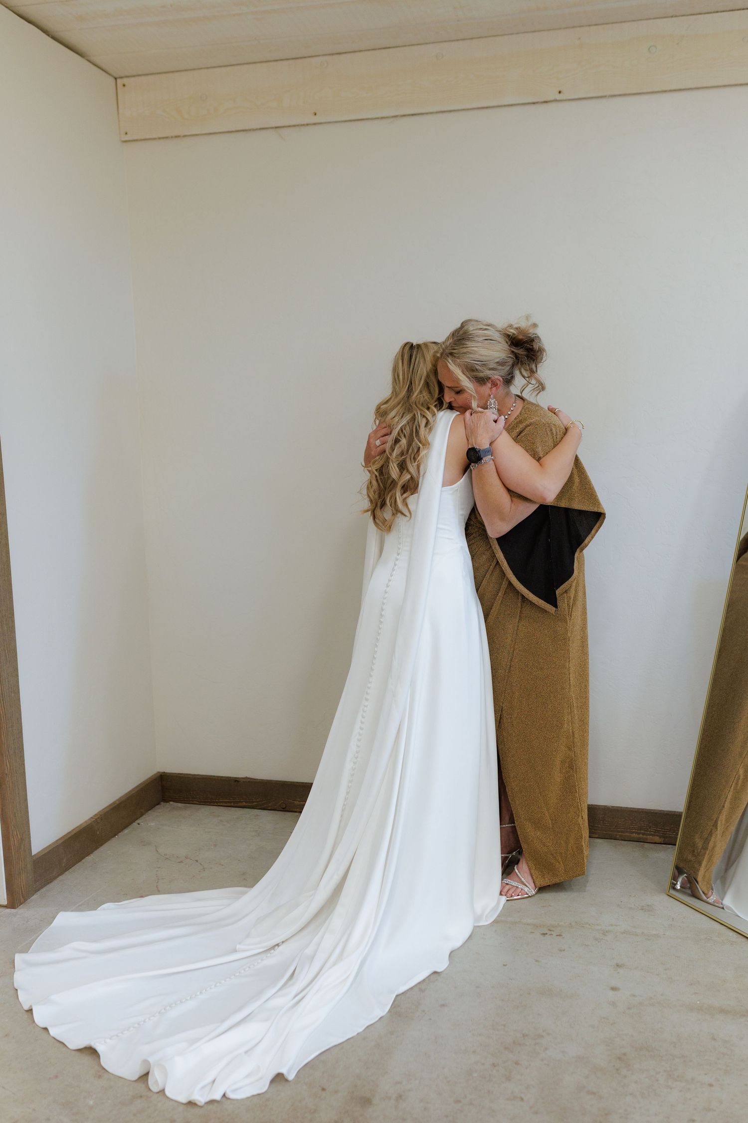 Bride sharing intimate moment with a hug from mom before she gets married at Montana wedding with mountain views