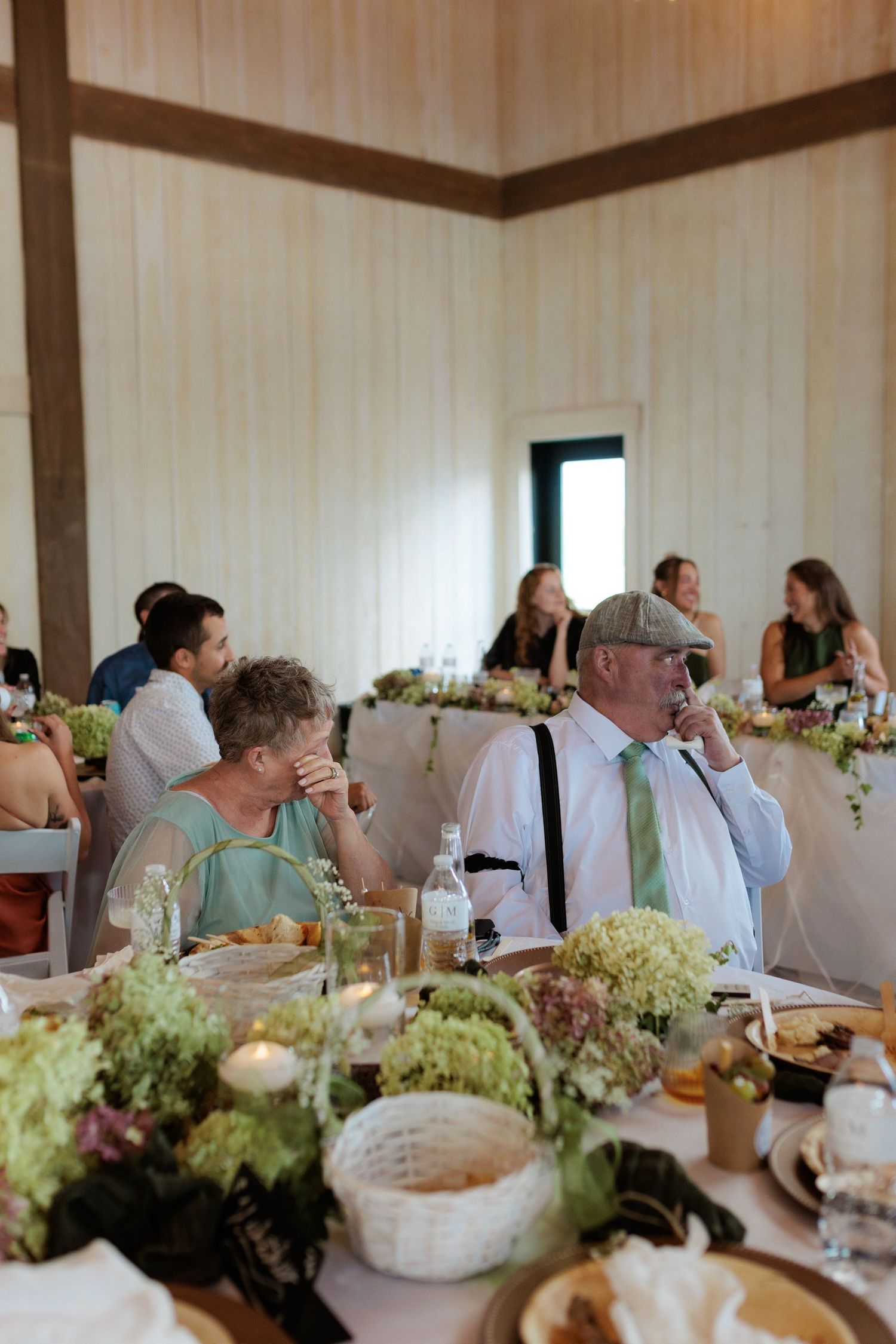 grandparents of the bride wiping away tears and getting emotional while listening to wedding speech at Montana wedding