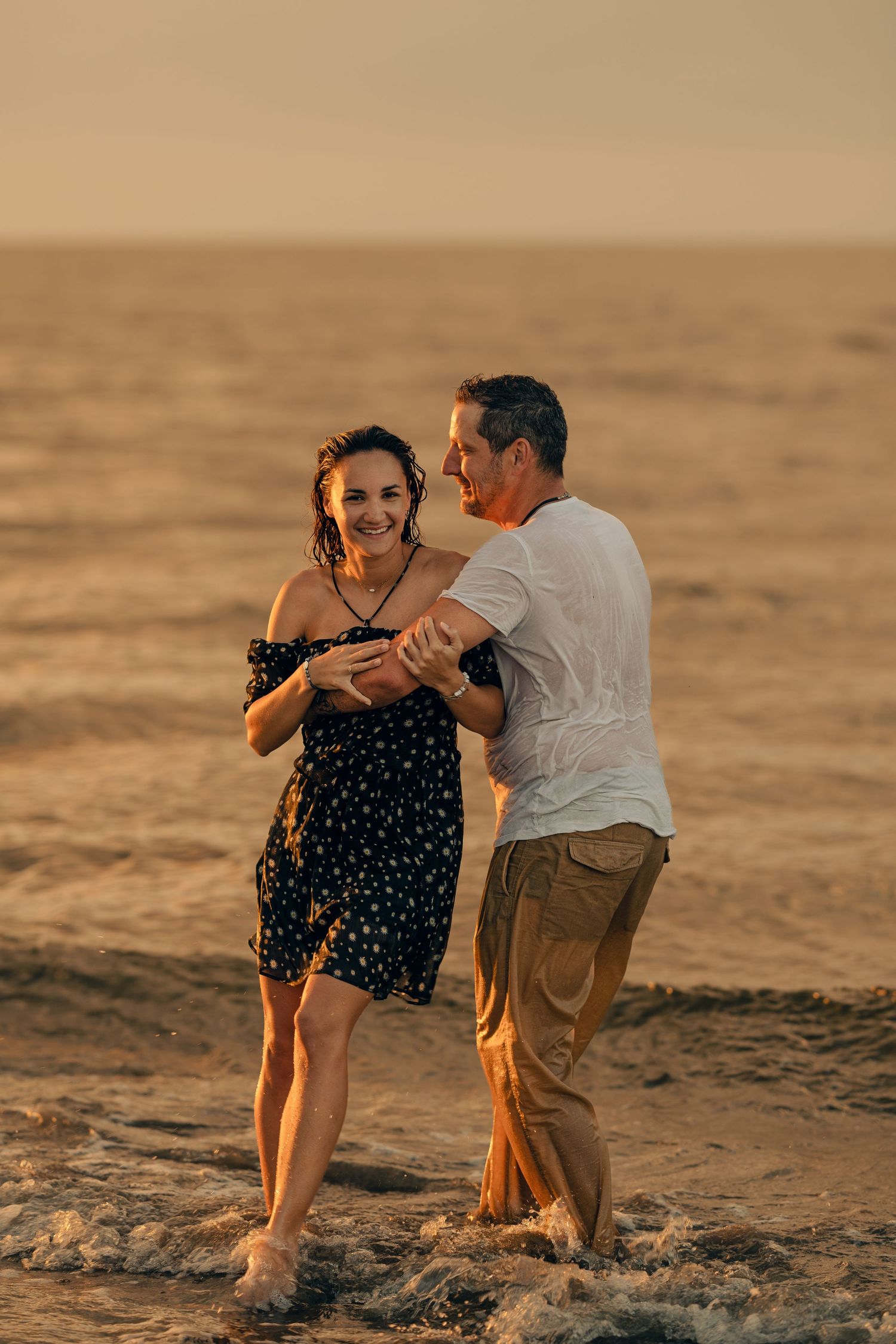 couple at sea playing water