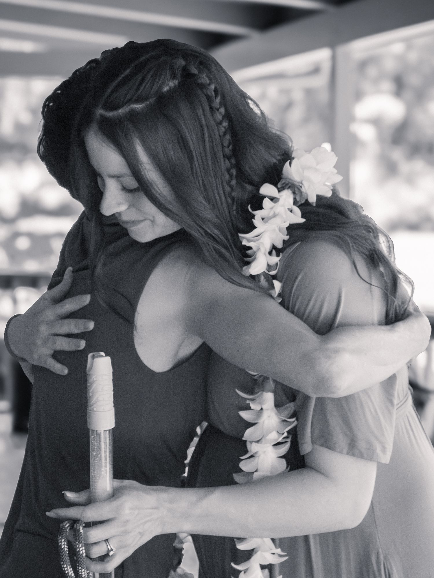 Black and white sequence showing emotional moments with women hugging and sharing drinks.