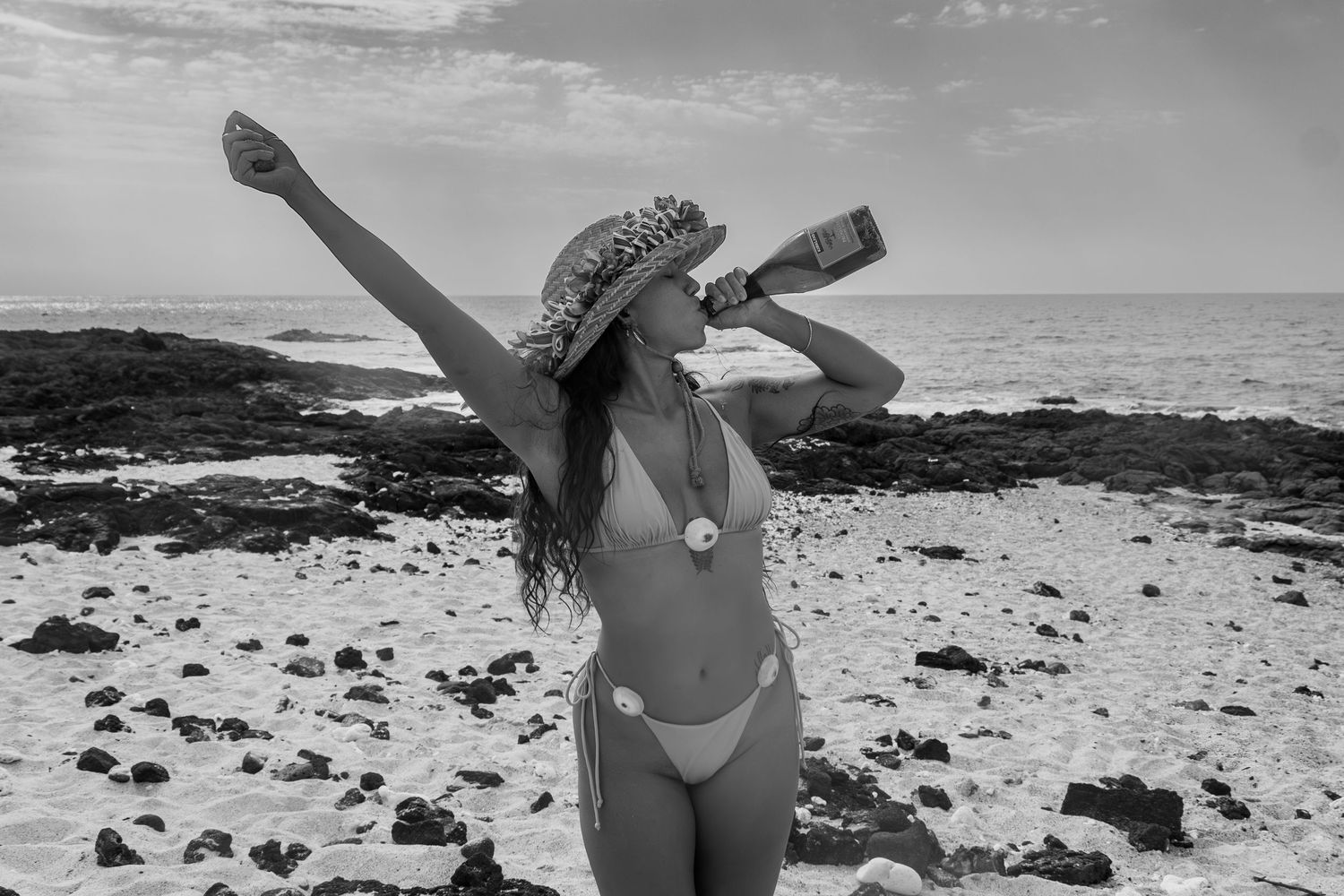 A black and white panoramic collage of beach scenes showing rocky coastline and birthday girl enjoying the seaside.