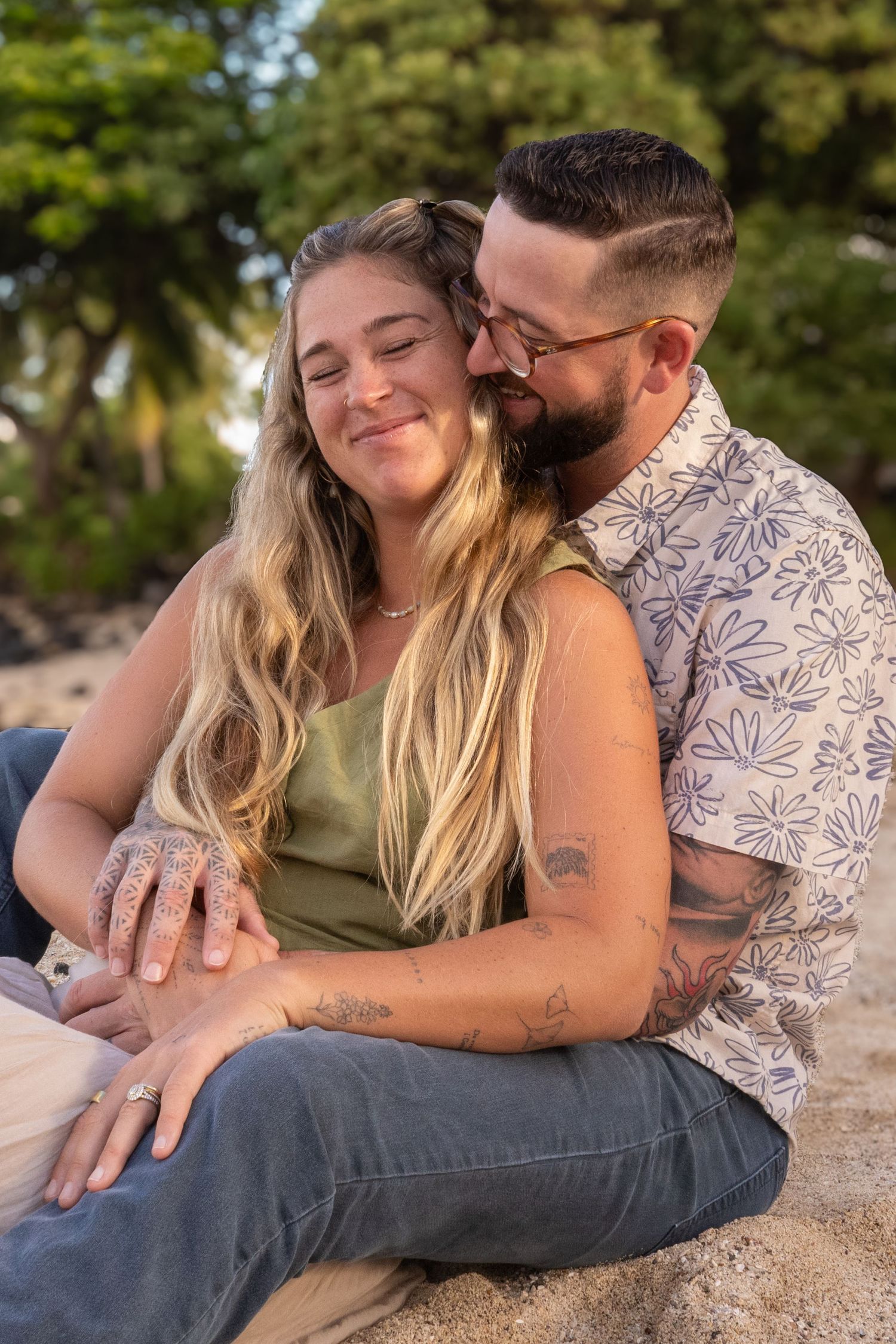 A couple embraces and shares affectionate moments on a beach during a sunset photoshoot.