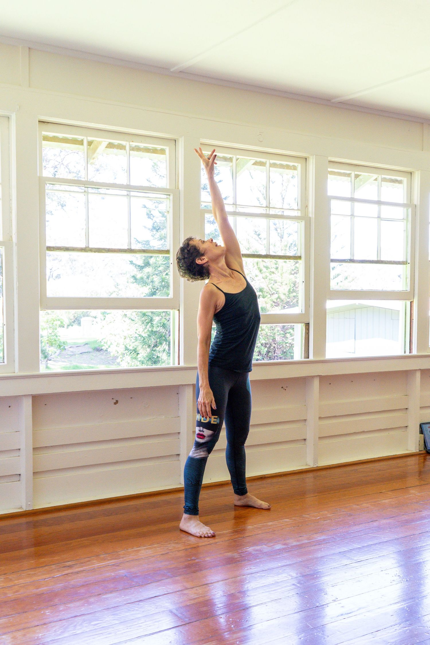 A series of yoga poses demonstrated in a bright studio with wooden floors and large windows.